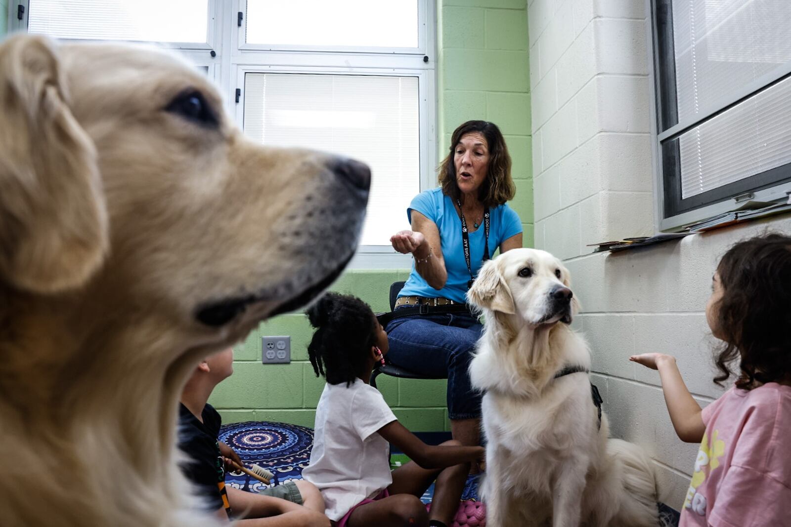 Community Gem Kathy Kleiser brings her two service Golden Retrievers Pepe and Quilo to Ruskin Elementary School to read and play with the children Monday July 15, 2024. JIM NOELKER/STAFF