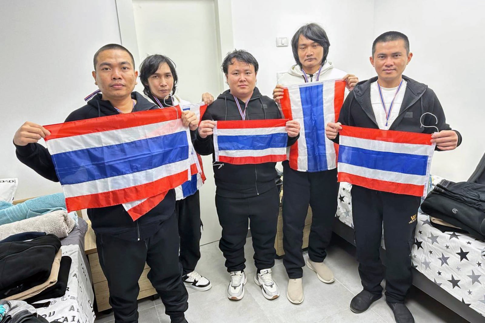 Thai hostages who were freed from Hamas, from left to right, Watchara Sriaoun, Pongsak Thaenna, Sathian Suwannakham, Surasak Rumnao, and Bannawat Saethao hold the Thailand flag in Israel, Thursday, Jan. 30, 2025. (Royal Thai Embassy in Tel Aviv via AP)