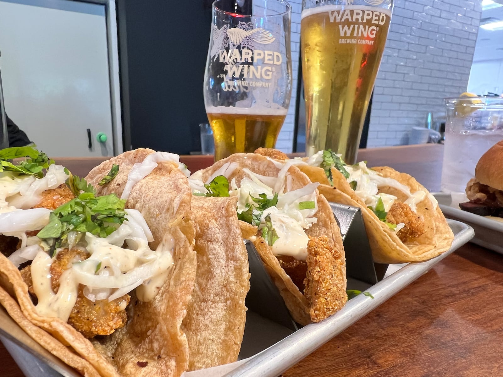 Warped Wing Brewery & Smokery's fish tacos paired with a cold beer. ALEXIS LARSEN/CONTRIBUTOR