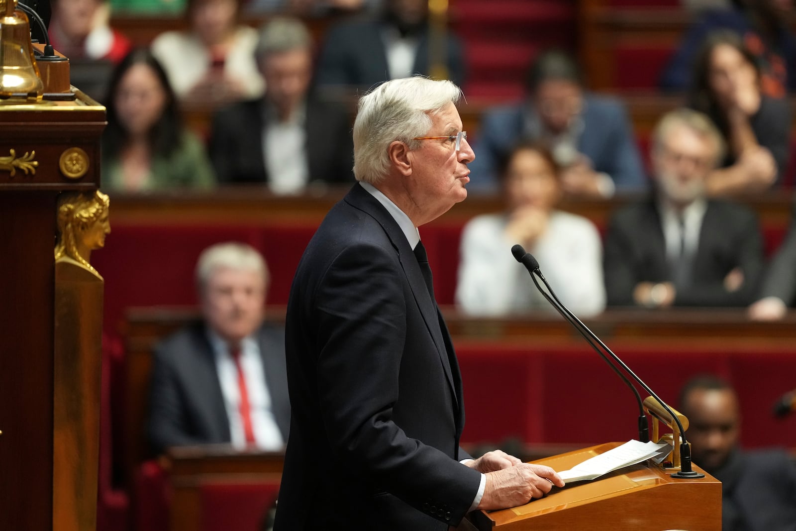 French Prime Minister Michel Barnier delivers his speech at the National Assembly while France's minority government may be on its last legs as opposition lawmakers moved this week toward a no-confidence vote, Monday, Dec. 2, 2024 in Paris. (AP Photo/Michel Euler)