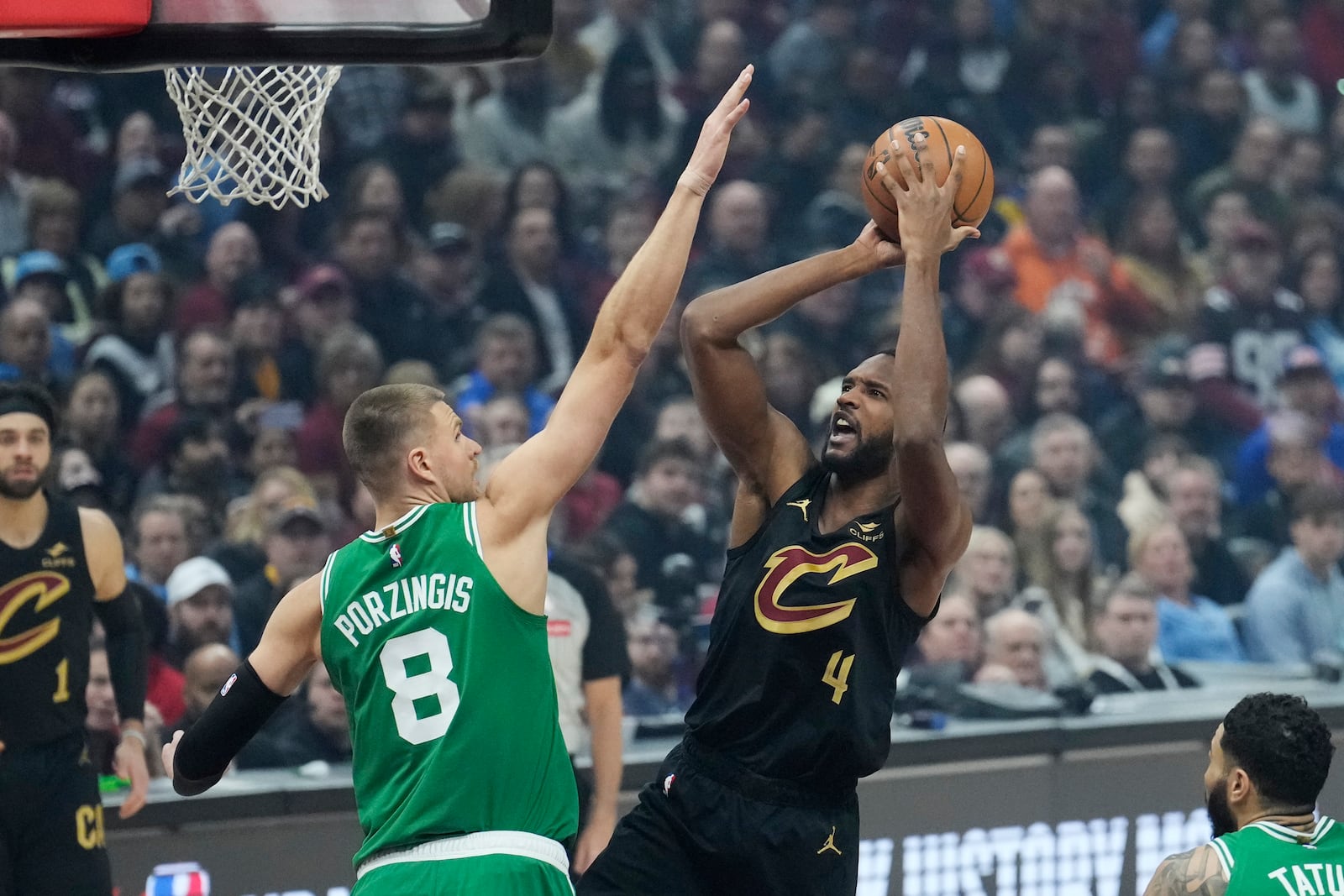 Cleveland Cavaliers forward Evan Mobley (4) shoots as Boston Celtics center Kristaps Porzingis (8) defends in the first half of an NBA basketball game, Tuesday, Feb. 4, 2025, in Cleveland. (AP Photo/Sue Ogrocki)