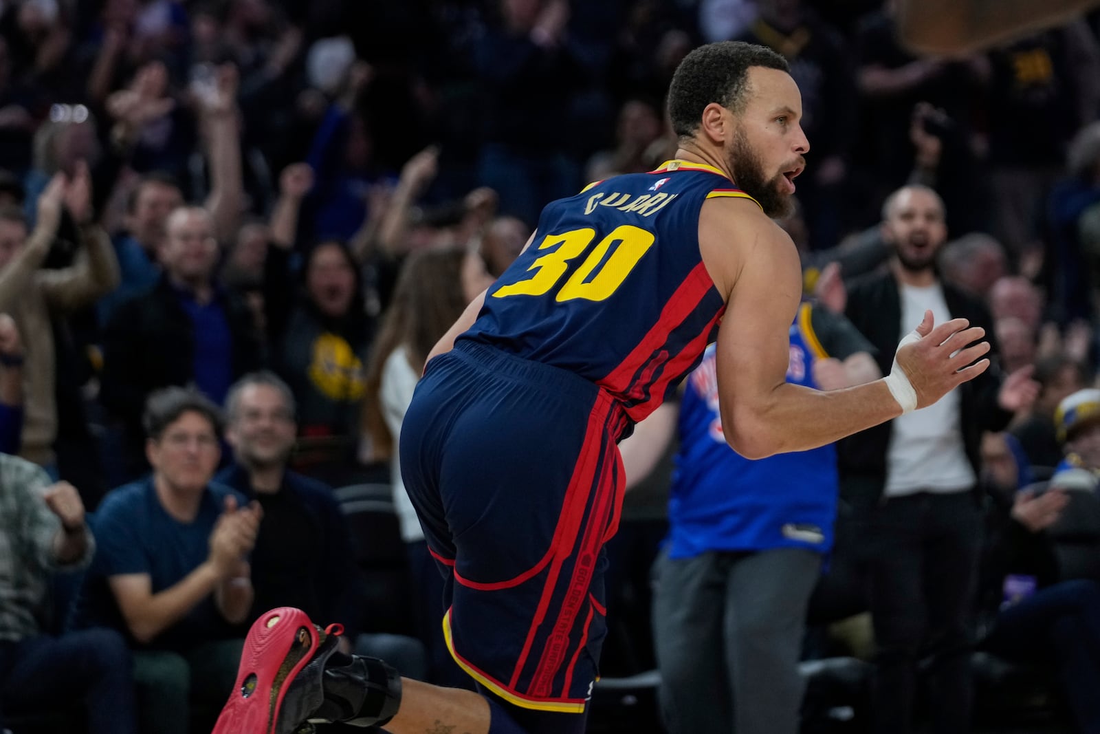 Golden State Warriors guard Stephen Curry reacts after scoring against the Miami Heat during the second half of an NBA basketball game Tuesday, Jan. 7, 2025, in San Francisco. (AP Photo/Godofredo A. Vásquez)