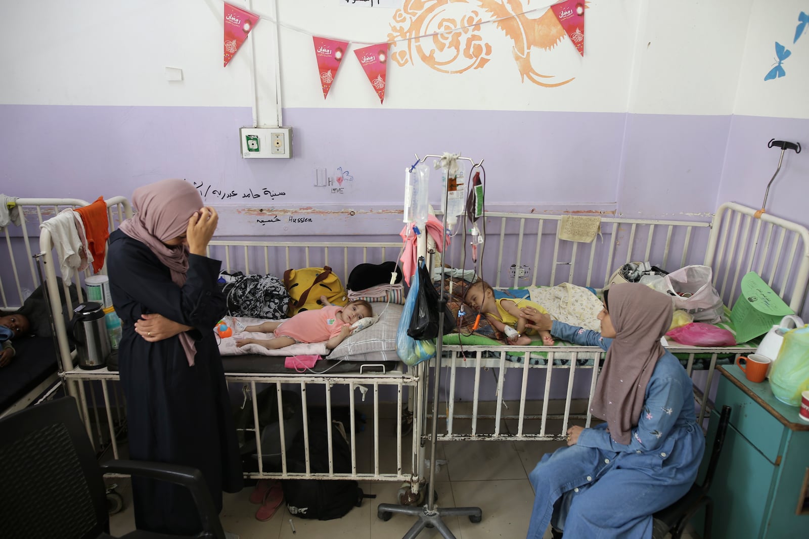 FILE - Amira Al-Jojo, left, stands beside her 10-month-old son, Yousef Al-Jojo, who suffers from malnutrition at Al-Aqsa Martyrs Hospital, where he is undergoing treatment, in Deir al-Balah in the central Gaza Strip on June 1, 2024. At right is Nuha Al-Khaldi and her child. (AP Photo/Jehad Alshrafi)