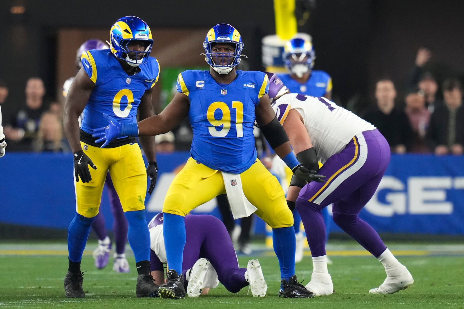 Los Angeles Rams defensive tackle Kobie Turner (91) celebrates sacking Minnesota Vikings quarterback Sam Darnold (14) during the first half of an NFL wild card playoff football game, Monday, Jan. 13, 2025, in Glendale, Ariz. (AP Photo/Ross D. Franklin)