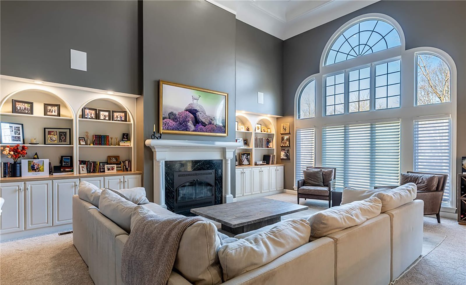 The two story great room has updated built in bookcases flanking the fireplace and a wall of windows with electric blinds.