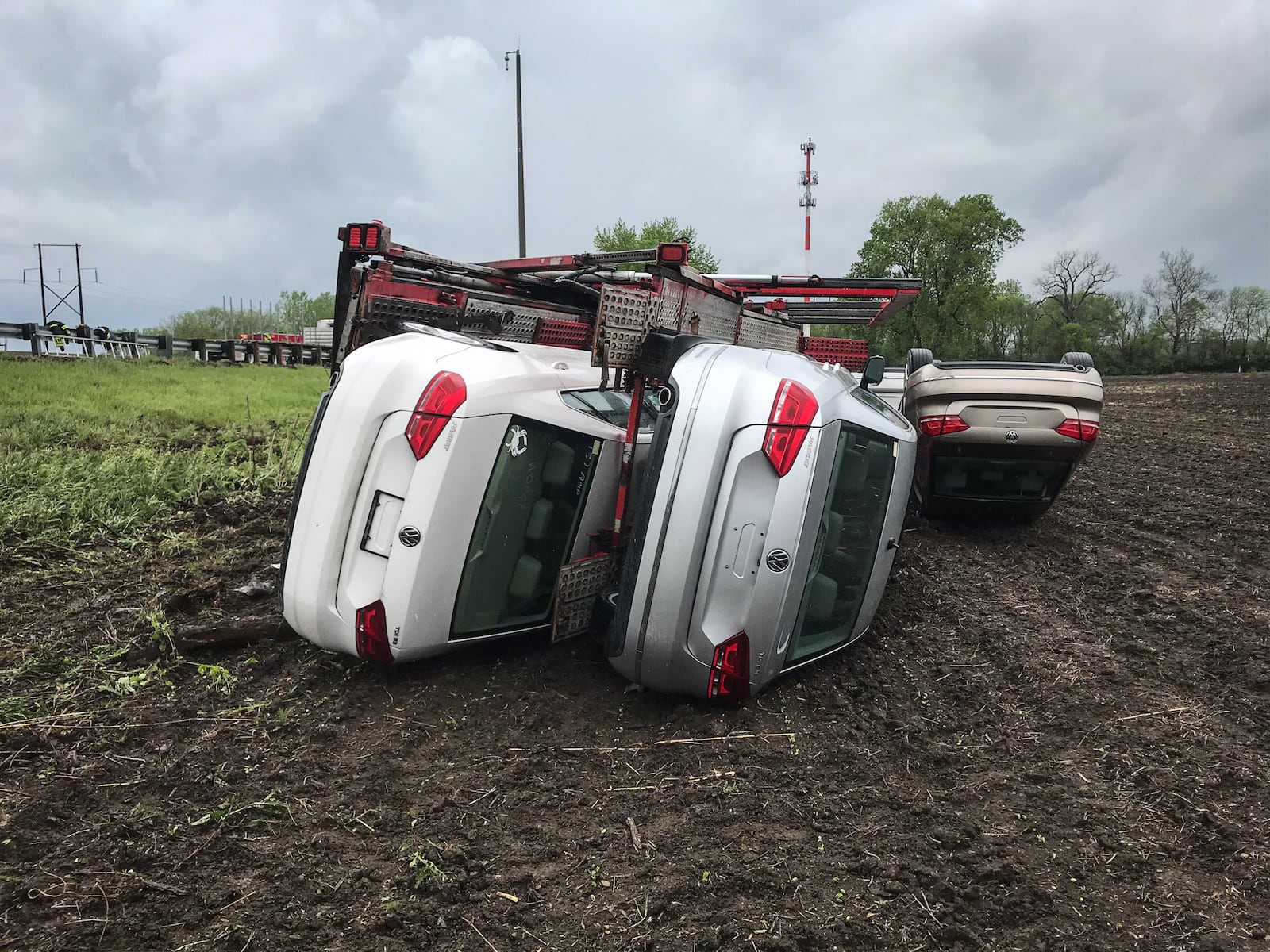 A truck hauling eight Volkswagens overturned into a cornfield off the right side of Interstate 70 West in Mad River Twp. in Clark County after crews said the driver tried to avoid another crash on the highway. JIM NOELKER / STAFF