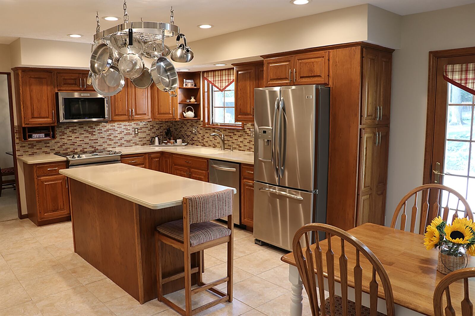 The extra-deep island provides plenty of work space, storage and seating. Cabinetry fills two walls and surrounds stainless-steel appliances. Solid-surface countertops provide plenty of work space, and a window is above the sink. CONTRIBUTED PHOTO BY KATHY TYLER