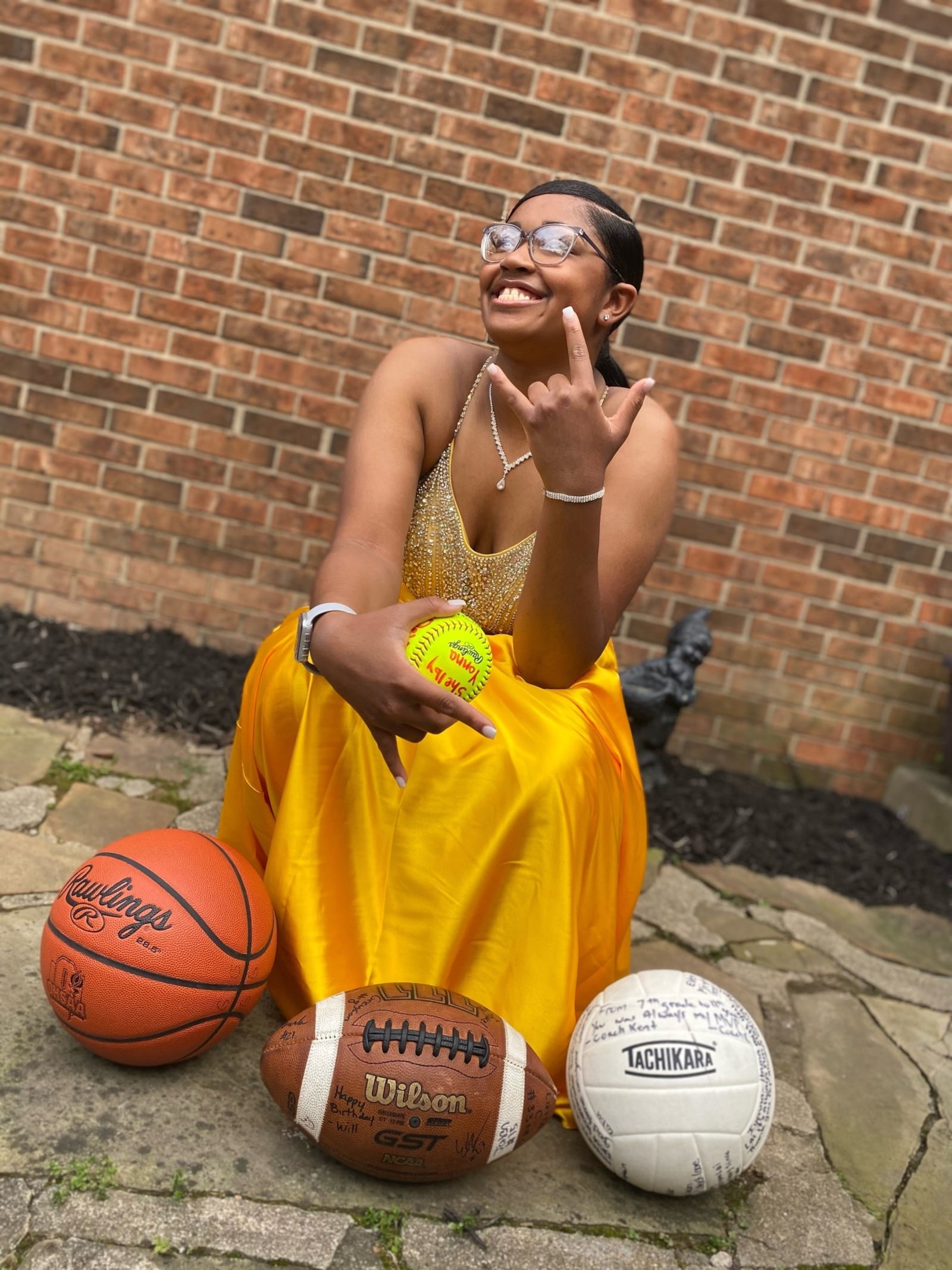 Laila Christmon in her prom dress with the balls of all four sports she played at Gamble Montessori High (Contributed Photo)