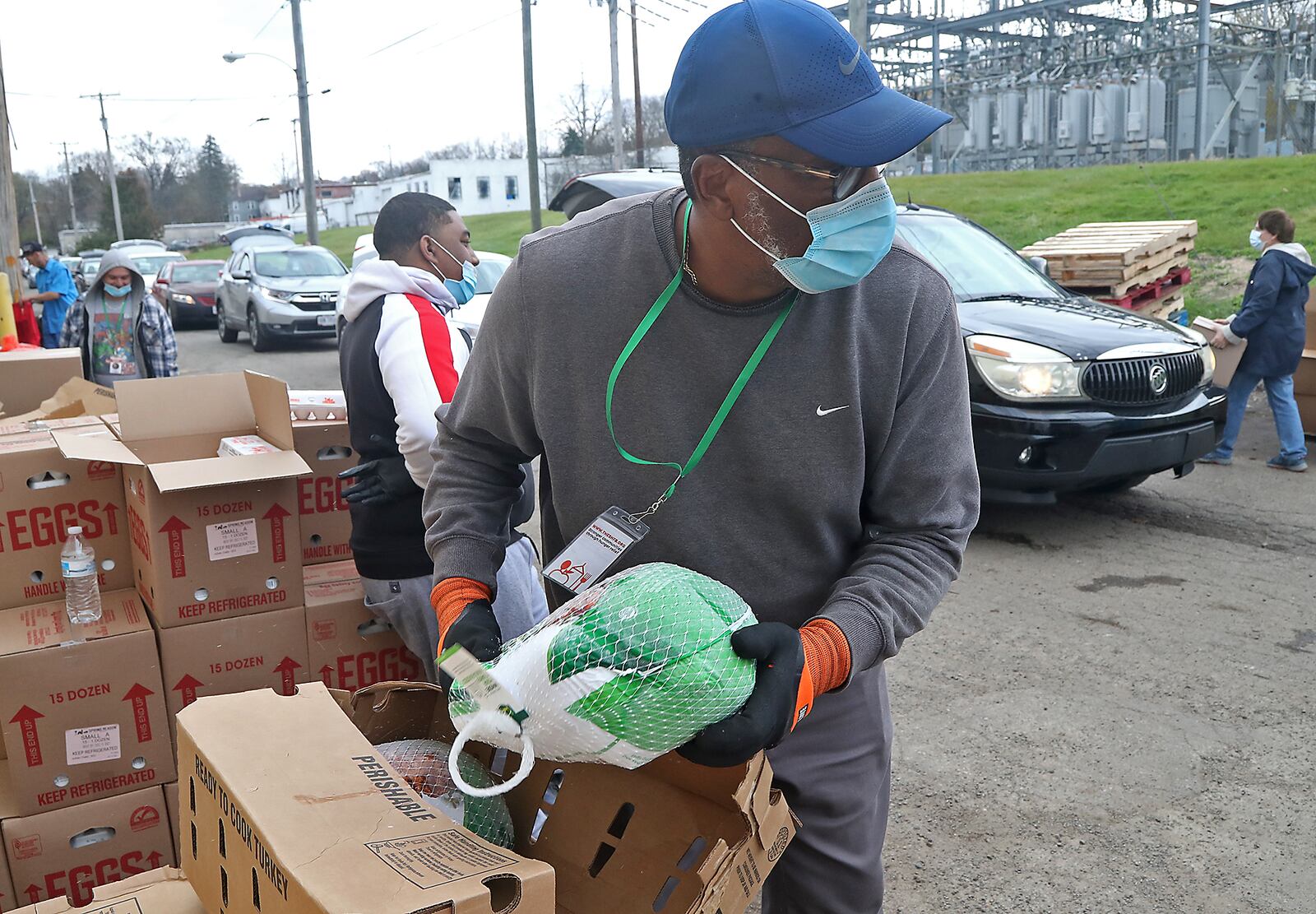 Volunteers at Second Harvest Food Bank fill up the trunks of cars with food for Thanksgiving Wednesday. A line of cars stretched for several blocks as people in need waited for food. BILL LACKEY/STAFF