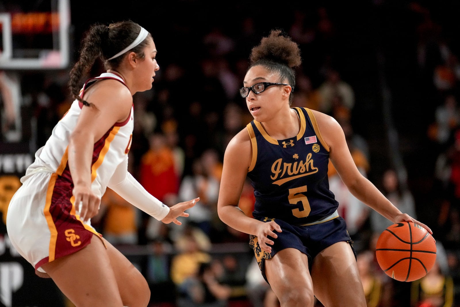 Notre Dame guard Olivia Miles (5) dribbles against Southern California guard Talia von Oelhoffen during the first half of an NCAA college basketball game, Saturday, Nov. 23, 2024 in Los Angeles. (AP Photo/Eric Thayer)