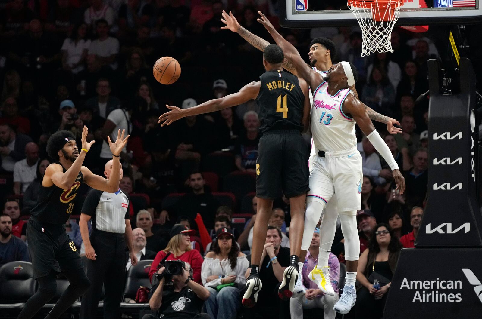 Cleveland Cavaliers forward Evan Mobley (4) passes the ball to center Jarrett Allen, left, as Miami Heat center Bam Adebayo (13) defends during the first half of an NBA basketball game, Wednesday, Jan. 29, 2025, in Miami. (AP Photo/Lynne Sladky)