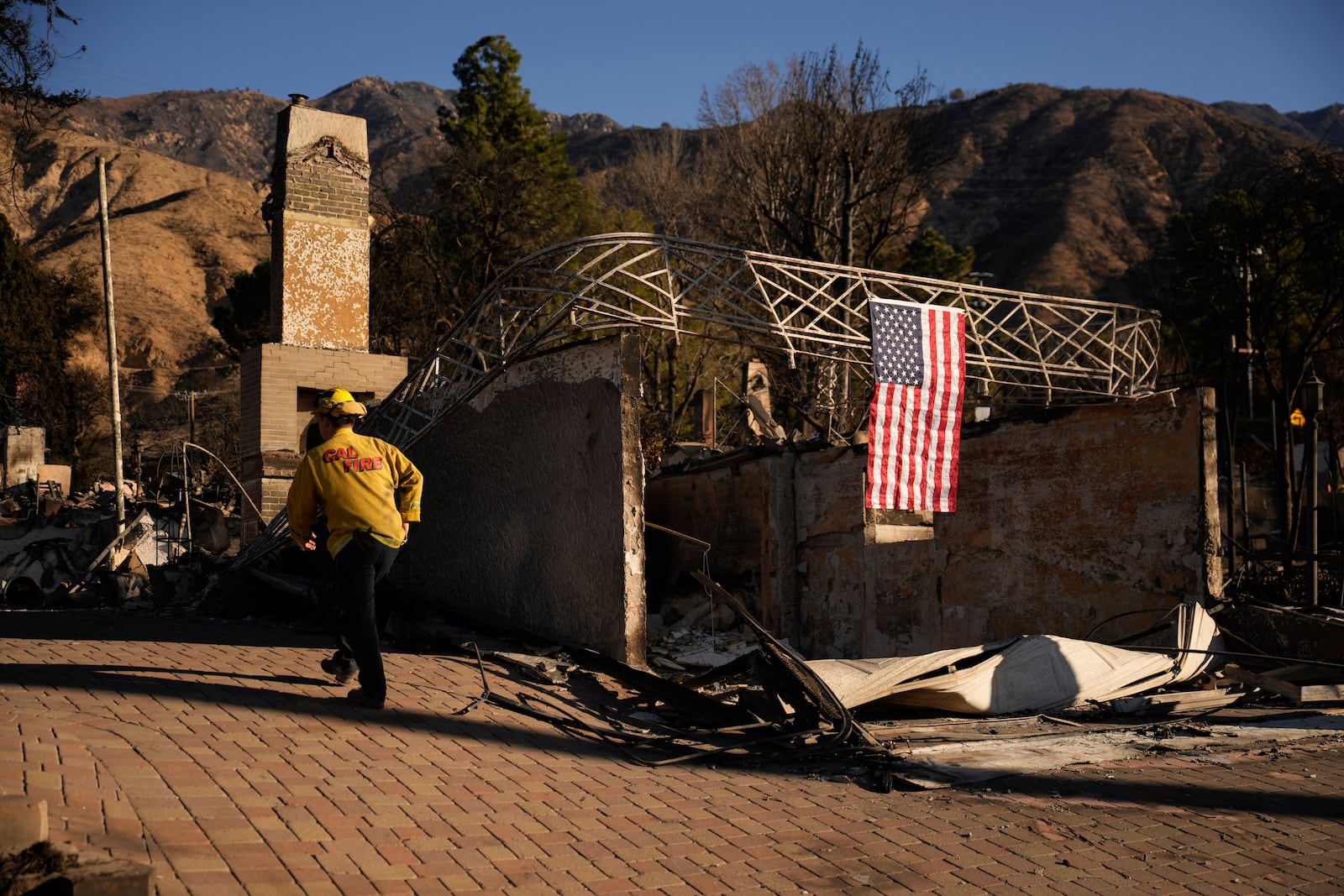 A firefighter inspects homes destroyed by the Eaton Fire in in Altadena, Calif., is seen Wednesday, Jan 15, 2025. (AP Photo/John Locher)