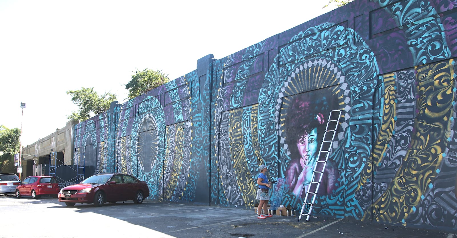 Tiffany Clark, founder of the Mural Machine, is creating a new mural at the entrance of the Oregon District in Dayton.  LISA POWELL / STAFF