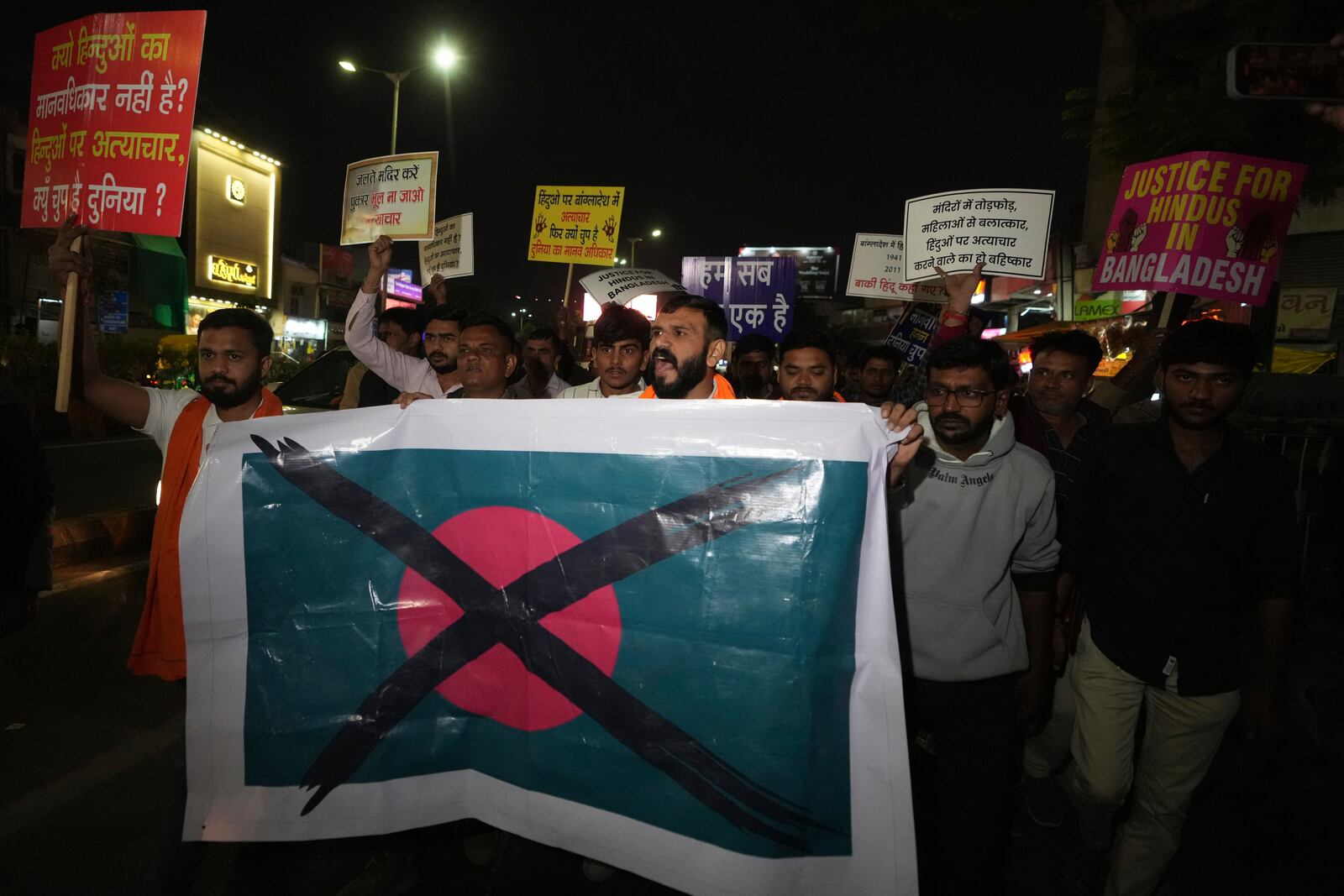 Activists of Bajarang dal, a Hindu rights group, carry a defaced symbolic flag of Bangladesh, during a protest against the alleged attacks on Hindus in Bangladesh, in Ahmedabad, India, Wednesday, Dec. 11, 2024. (AP Photo/Ajit Solanki)