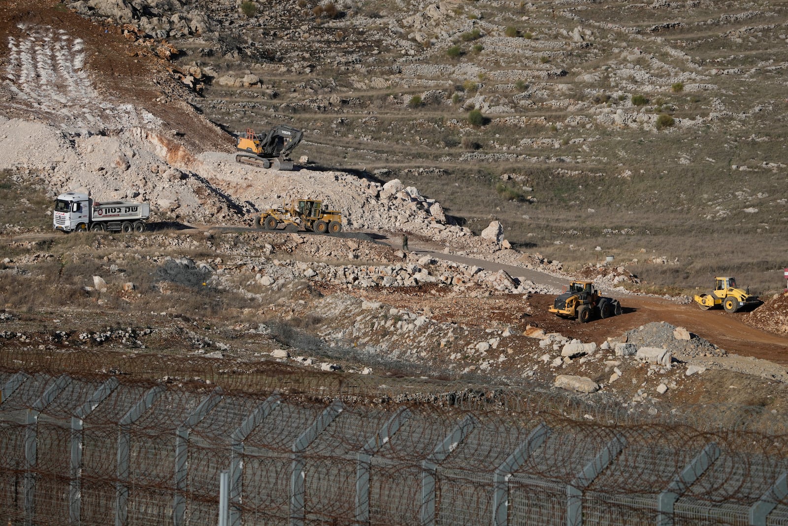 Israeli bulldozers maneuver near the so-called Alpha Line that separates the Israeli-controlled Golan Heights from Syria, in the town of Majdal Shams, Monday, Dec. 16, 2024. (AP Photo/Matias Delacroix)