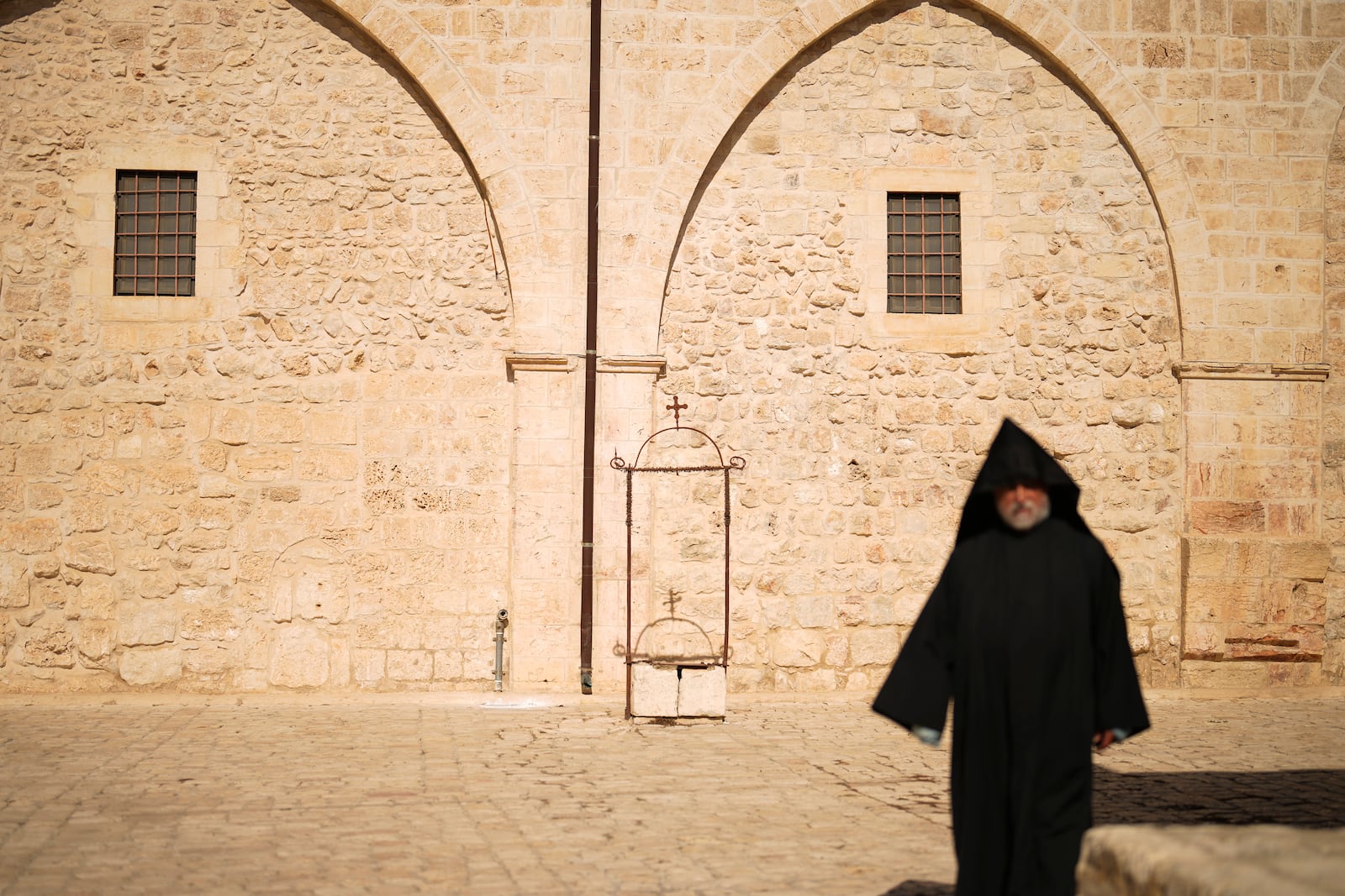 An Armenian Christian priest walks along the main square of the Armenian quarter in Jerusalem, Thursday, Nov. 21, 2024. (AP Photo/Francisco Seco)