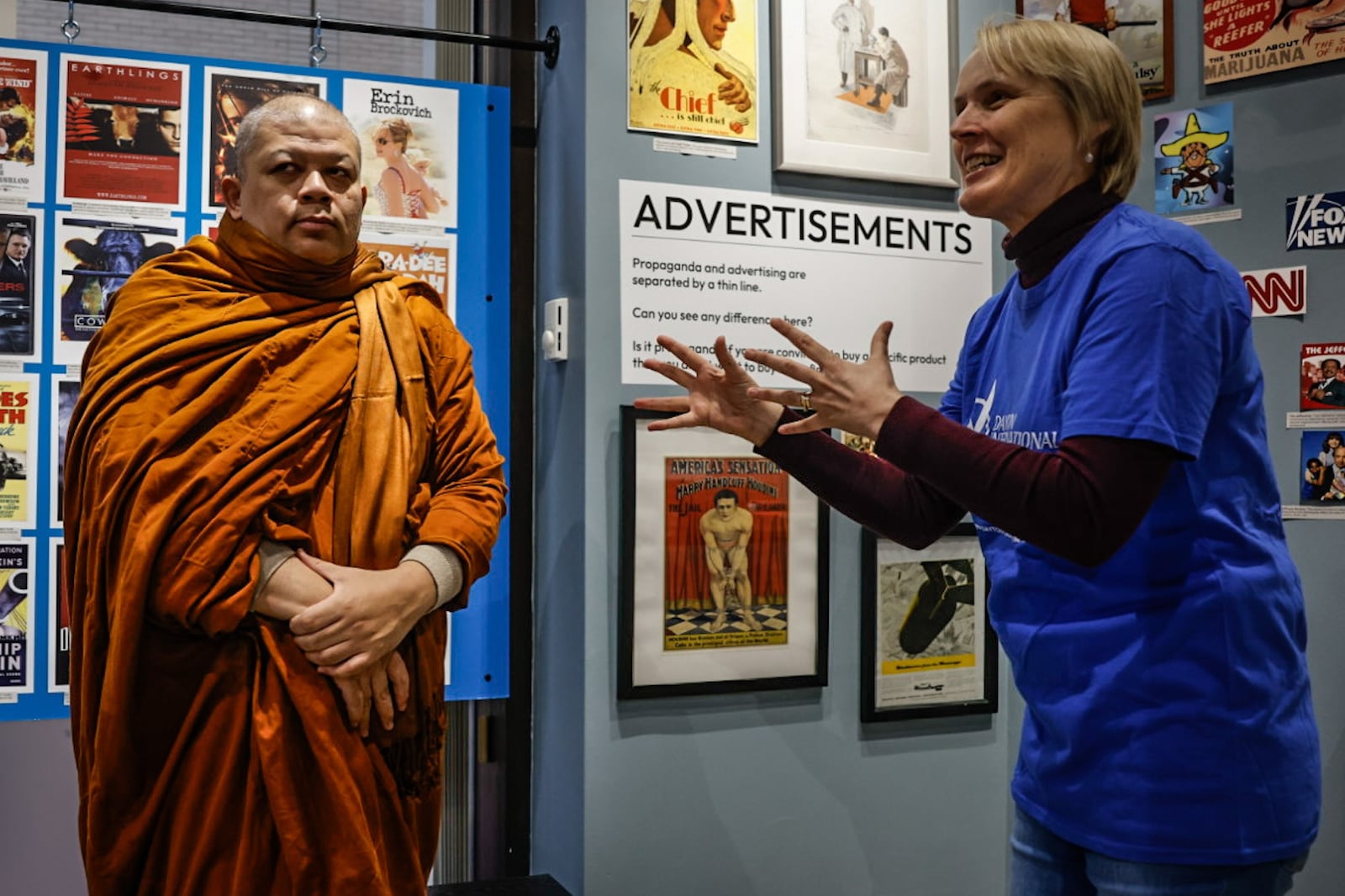 Buddhist monk from Thailand Pramote Pantapat, left, listens to International Peace Museum volunteer Sue Press talk about the items in the museum's exhibition Friday, January 26, 2024. The museum launched "A Season for Nonviolence" campaign to address hate crimes and violence. JIM NOELKER/STAFF