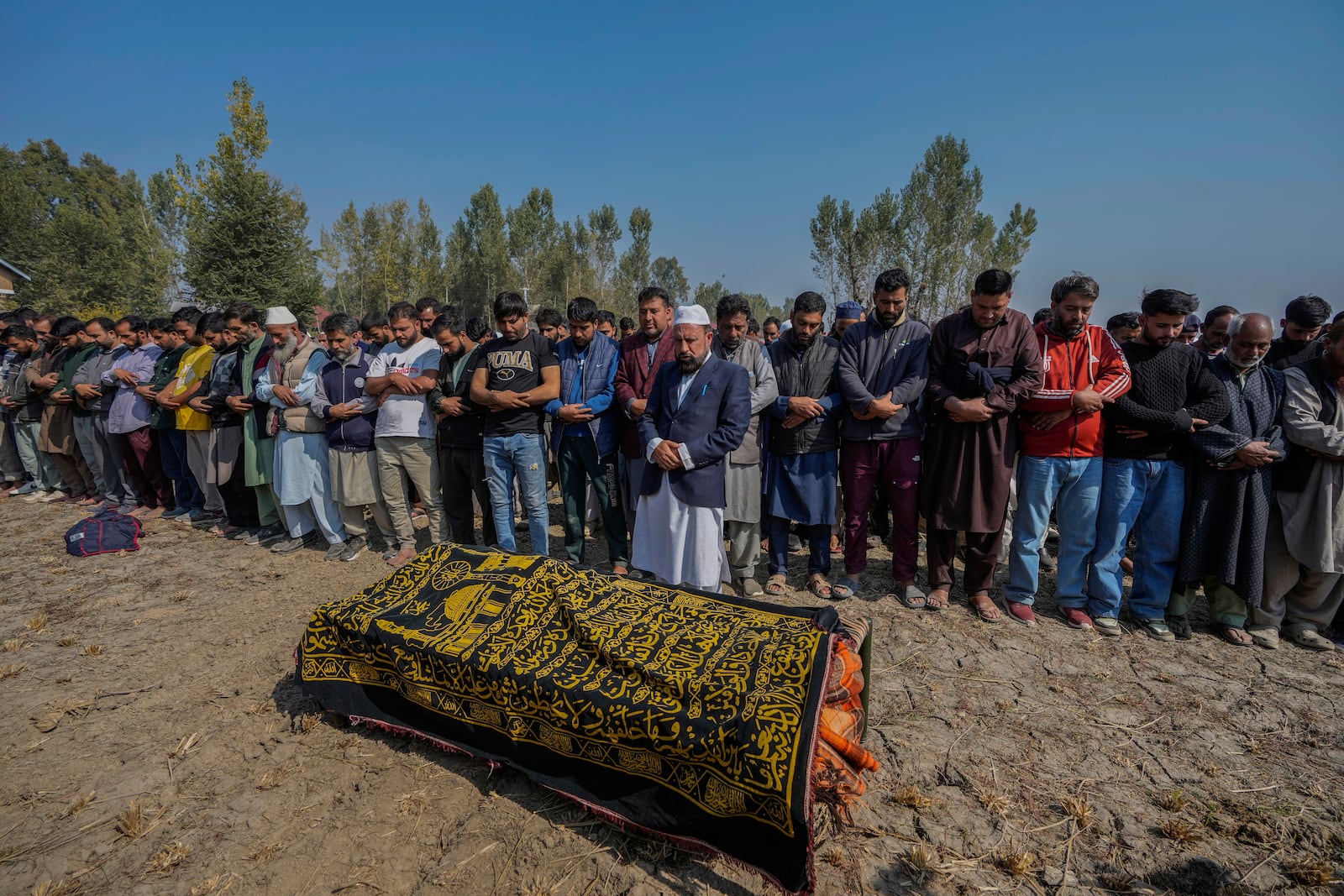 Villagers offer funeral prayers near the body of Kashmiri doctor Shahnawaz who was among those killed when gunmen fired at people working on a strategic tunnel project in Indian-controlled Kashmir, at Nadigam village southwest of Srinagar, Monday, Oct. 21, 2024. (AP Photo/Mukhtar Khan)