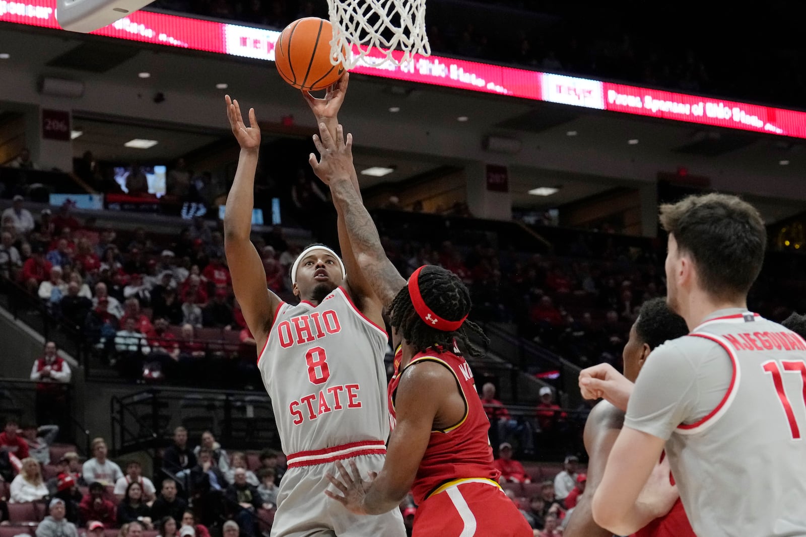 Ohio State guard Micah Parrish (8) shoots over Maryland guard Selton Miguel, center, in the second half of an NCAA college basketball game Thursday, Feb. 6, 2025, in Columbus, Ohio. (AP Photo/Sue Ogrocki)