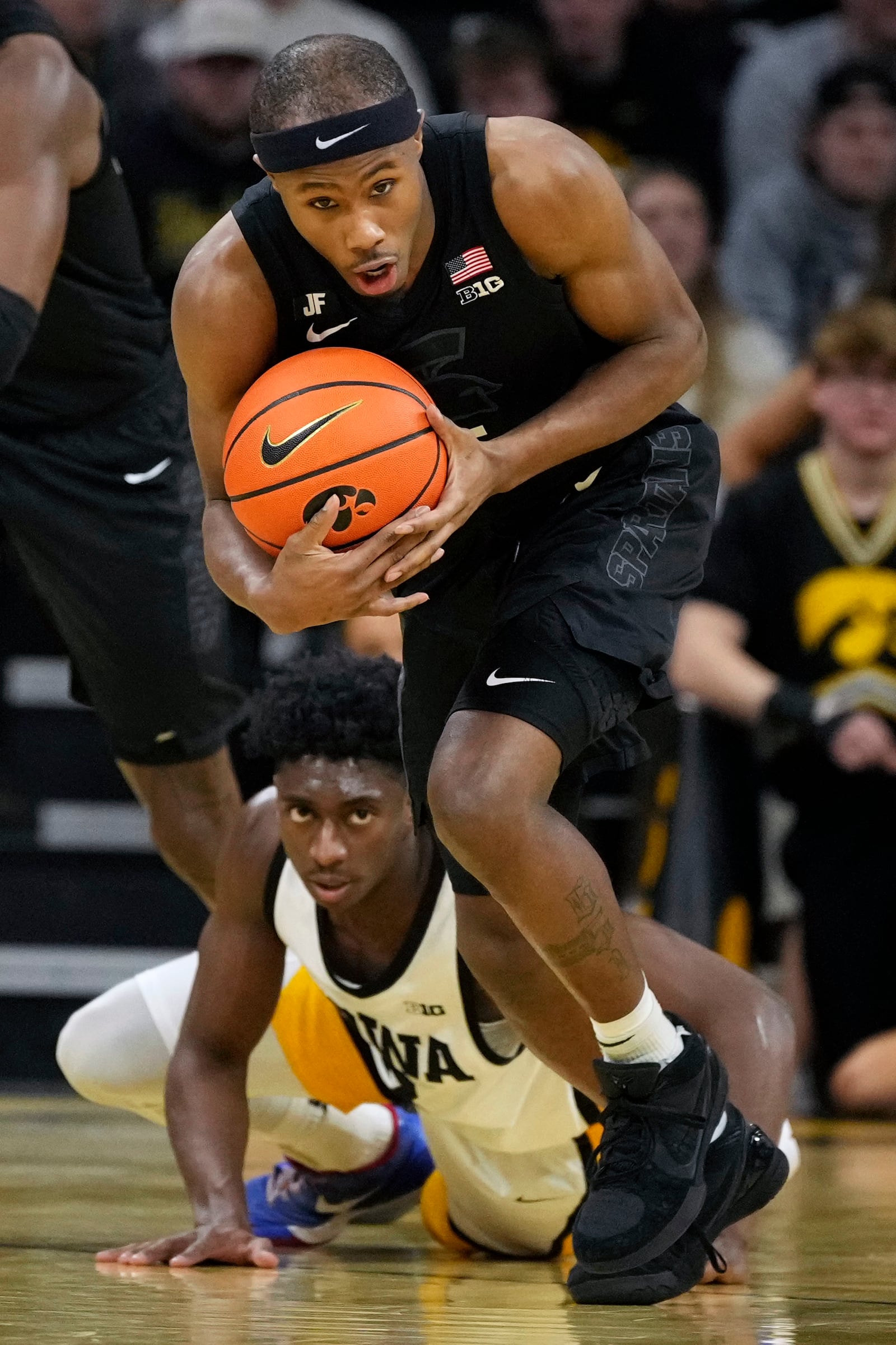 Michigan State guard Tre Holloman drives up court after stealing the ball from Iowa guard Drew Thelwell, rear, during the first half of an NCAA college basketball game, Thursday, March 6, 2025, in Iowa City, Iowa. (AP Photo/Charlie Neibergall)