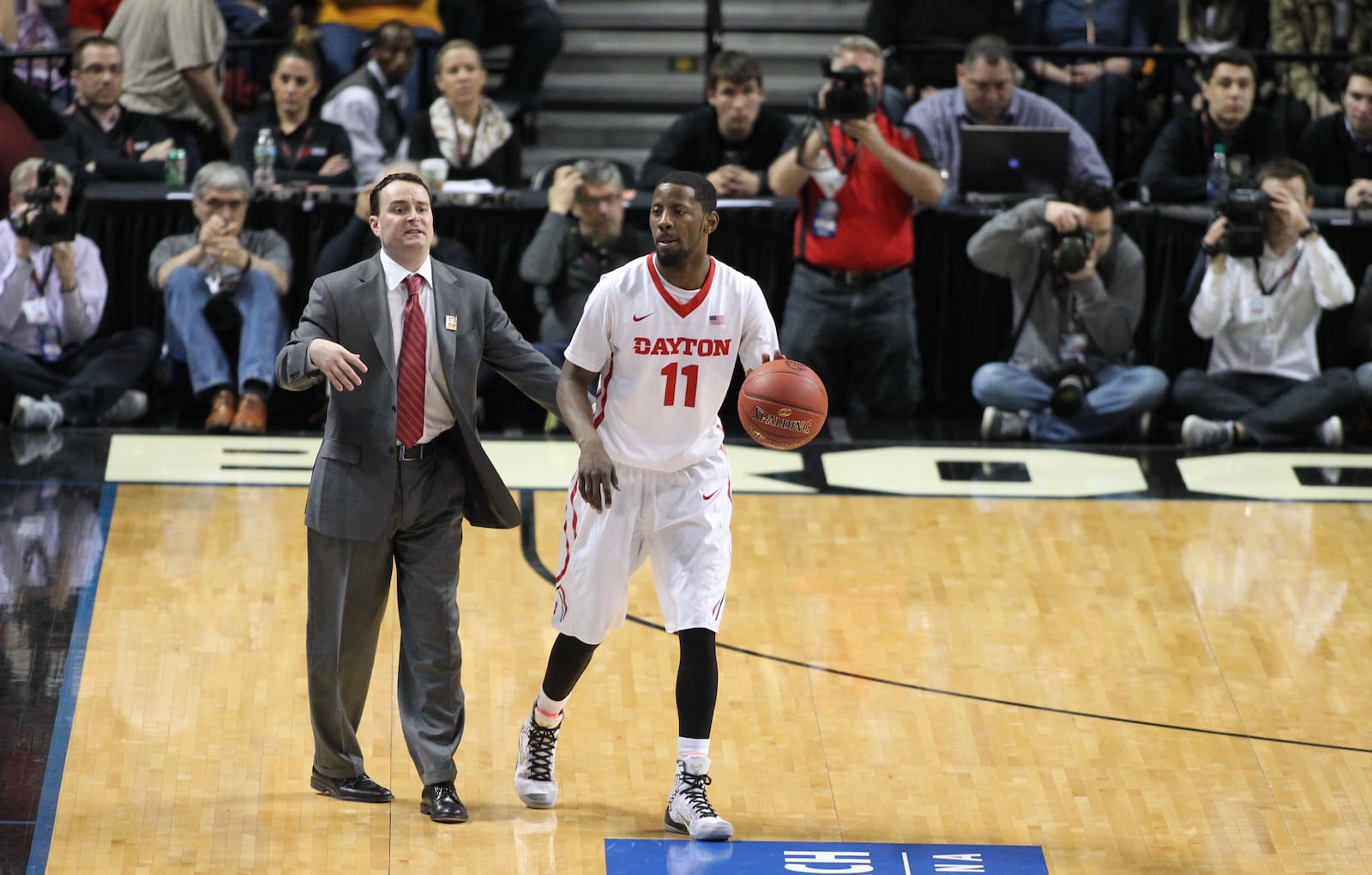 Dayton coach Archie Miller goes out on the court during play to talk to Scoochie Smith in the first half against St. Joseph's in the semifinals of the Atlantic 10 tournament on Saturday, March 12, 2016, at the Barclays Center in Brooklyn, N.Y. David Jablonski/Staff