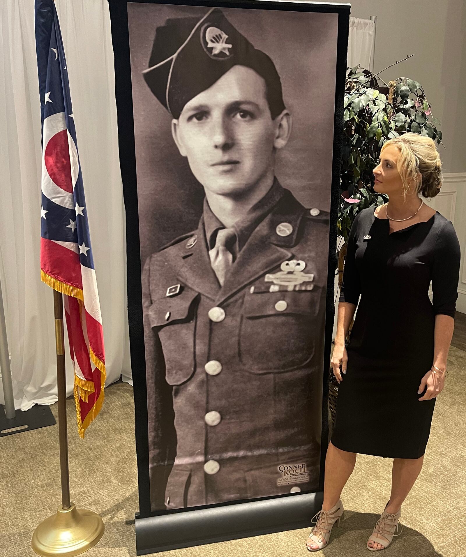 Country singer/songwriter Karen Waldrup stands next to an enlarged image of World War II veteran Jim "Pee Wee" Martin set up for his funeral service Wednesday, Sept. 21, 2022. Photo courtesy Ron Kaplan