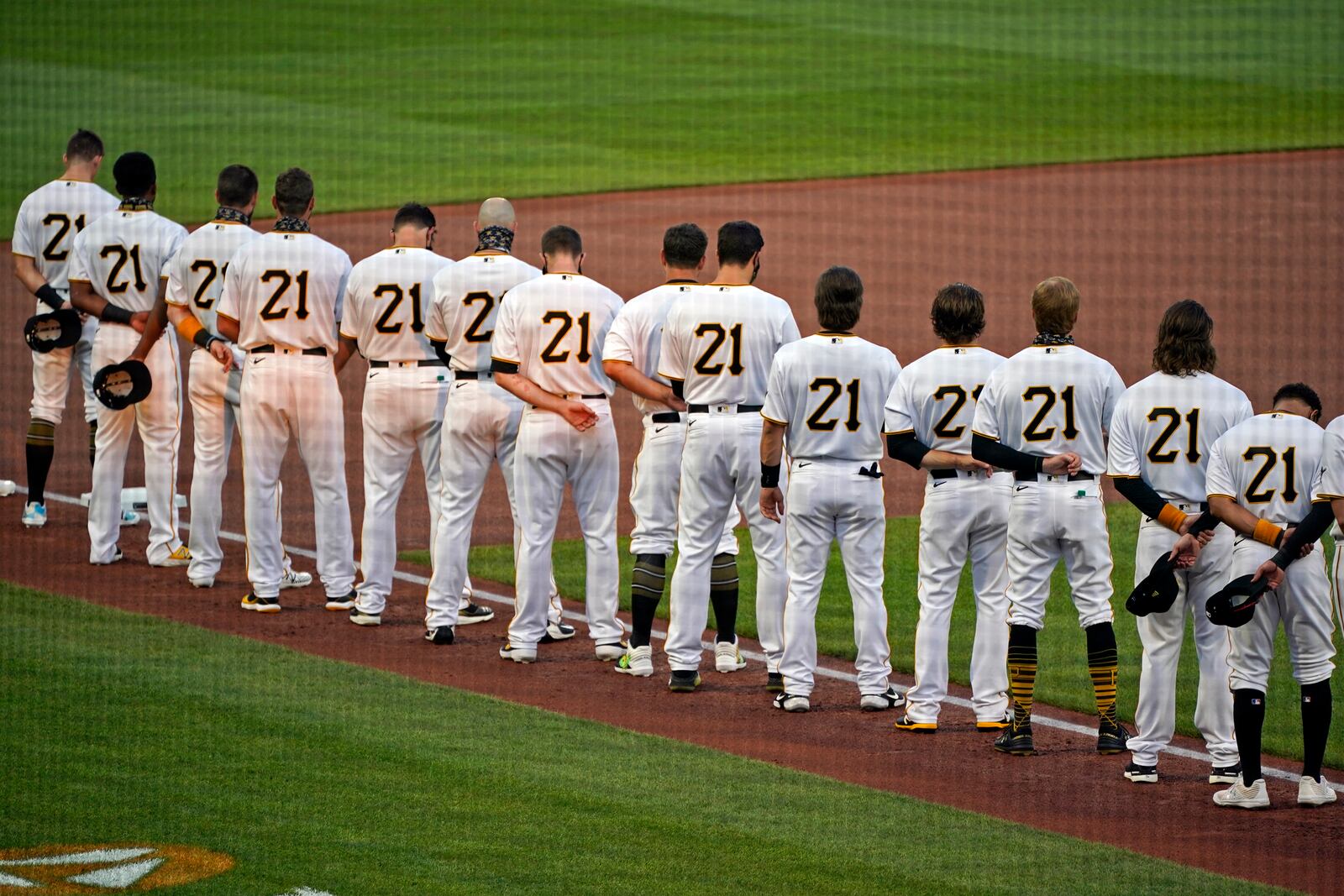 The Pittsburgh Pirates, all wearing Roberto Clemente's No. 21 for Roberto Clemente Day, watch a tribute to the Pirates Hall of Fame right fielder before the team's baseball game against the Chicago White Sox in Pittsburgh, Wednesday, Sept. 9, 2020. (AP Photo/Gene J. Puskar)