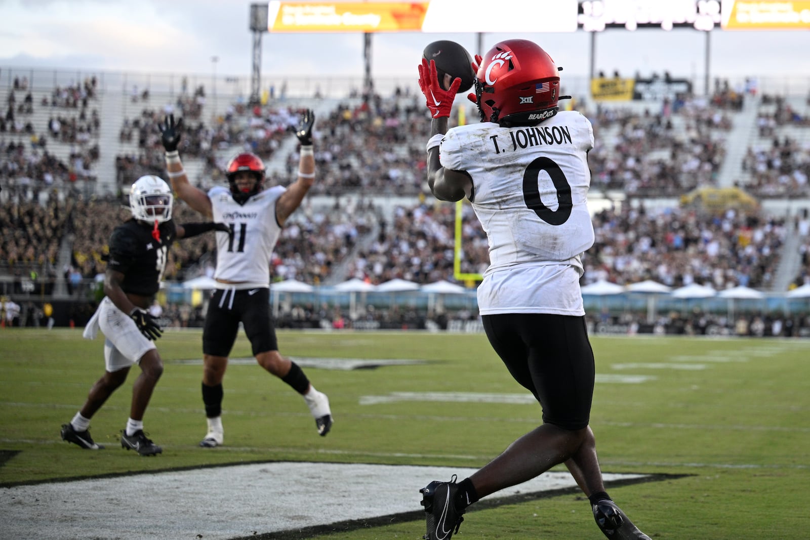 Cincinnati wide receiver Tony Johnson (0) catches a pass in the end zone for a 4-yard touchdown against Central Florida during the second half of an NCAA college football game, Saturday, Oct. 12, 2024, in Orlando, Fla. (AP Photo/Phelan M. Ebenhack)