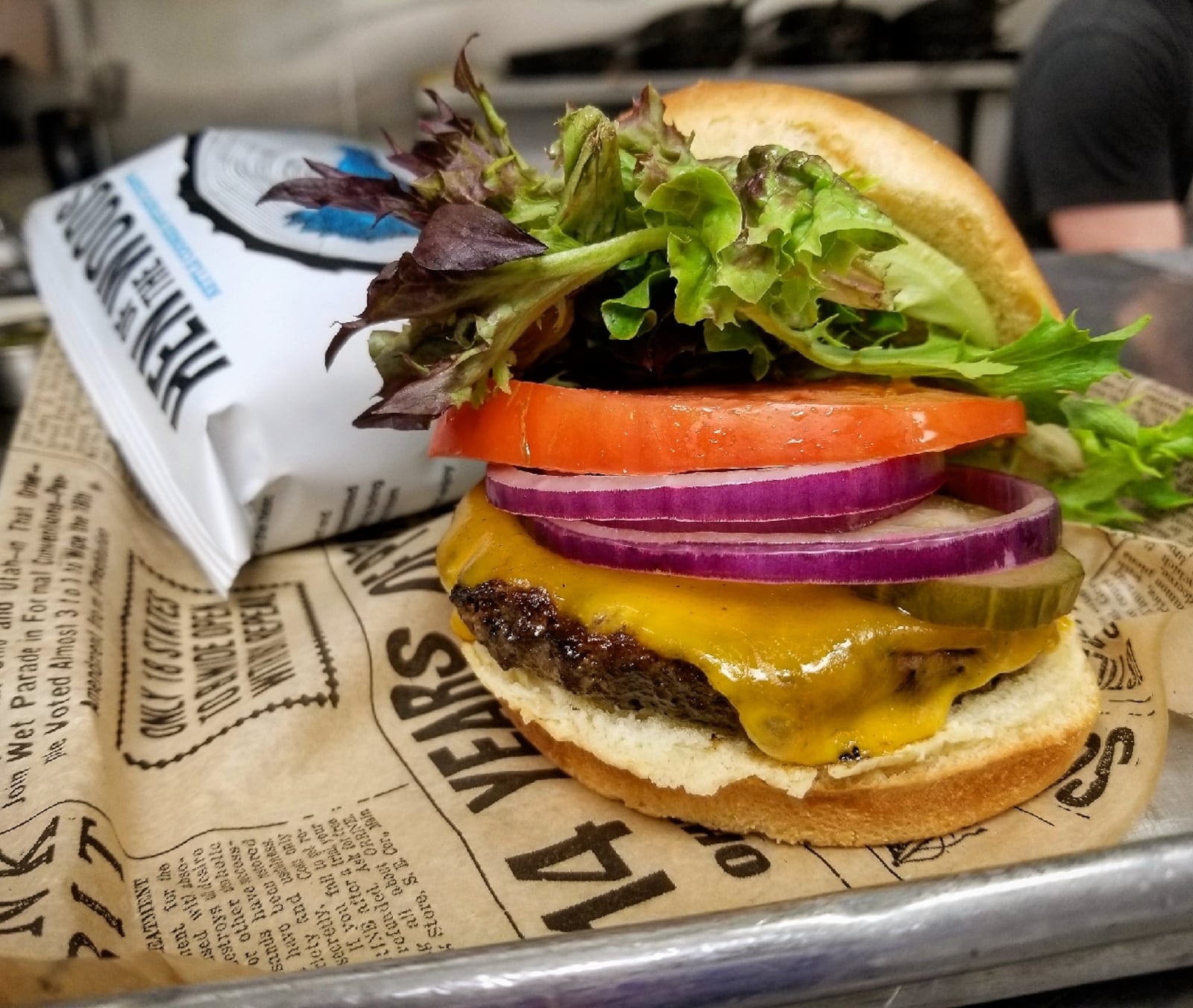 Mudlick Tap House The OG: a 1/3 lb. Blackhawk Farms Beef Patty on brioche piled with lettuce, tomato, onion, pickle with melted cheddar.