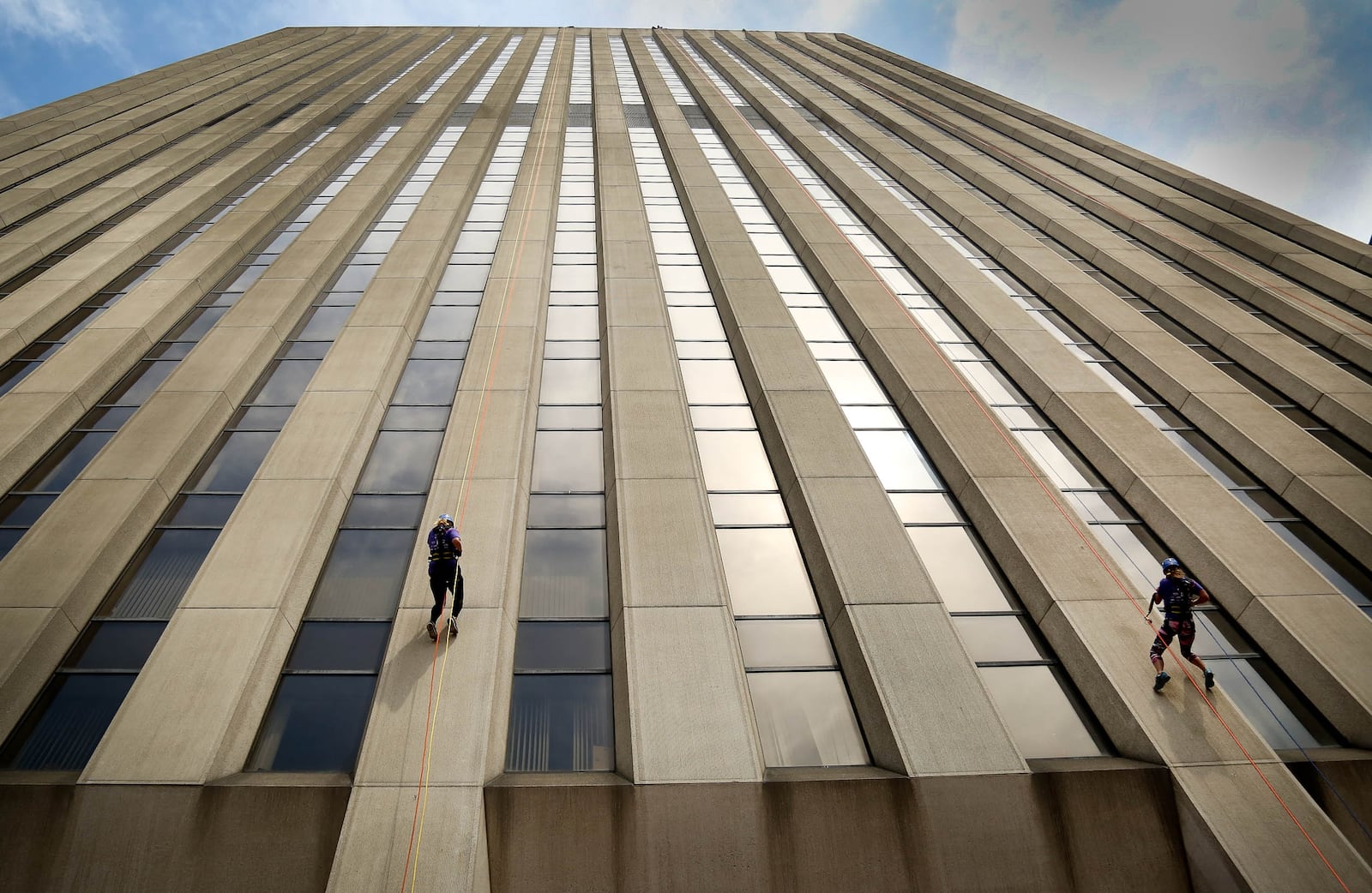 Courtney Cunningham (left) and Sarah Labs descend the 27-story KeyBank Tower on Friday afternoon, Aug. 14, 2015, as part of a unique fundraiser that supports Big Brothers Big Sisters of the Greater Miami Valley. The Over the Edge fundraiser was back for the fifth year with the goal of raising $140,000 in 2015. JIM WITMER/STAFF