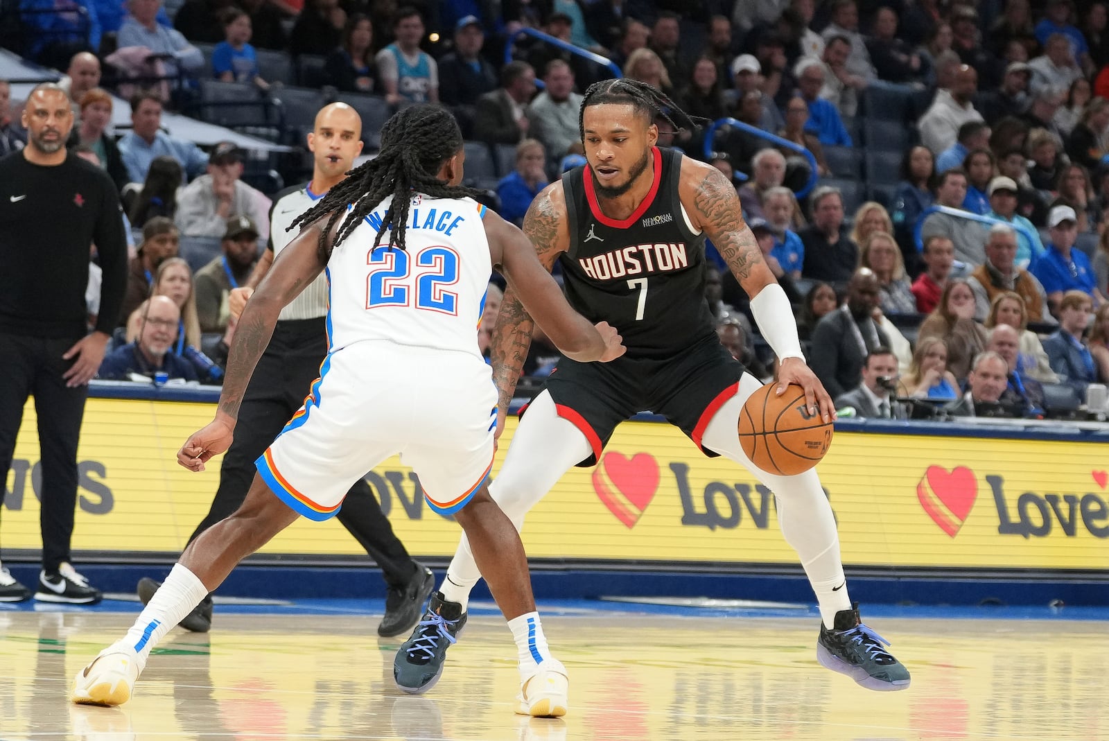 Houston Rockets forward Cam Whitmore (7) looks for an opening past Oklahoma City Thunder guard Cason Wallace (22) during the second half of an NBA basketball game, Monday, March 3, 2025, in Oklahoma City. (AP Photo/Kyle Phillips)