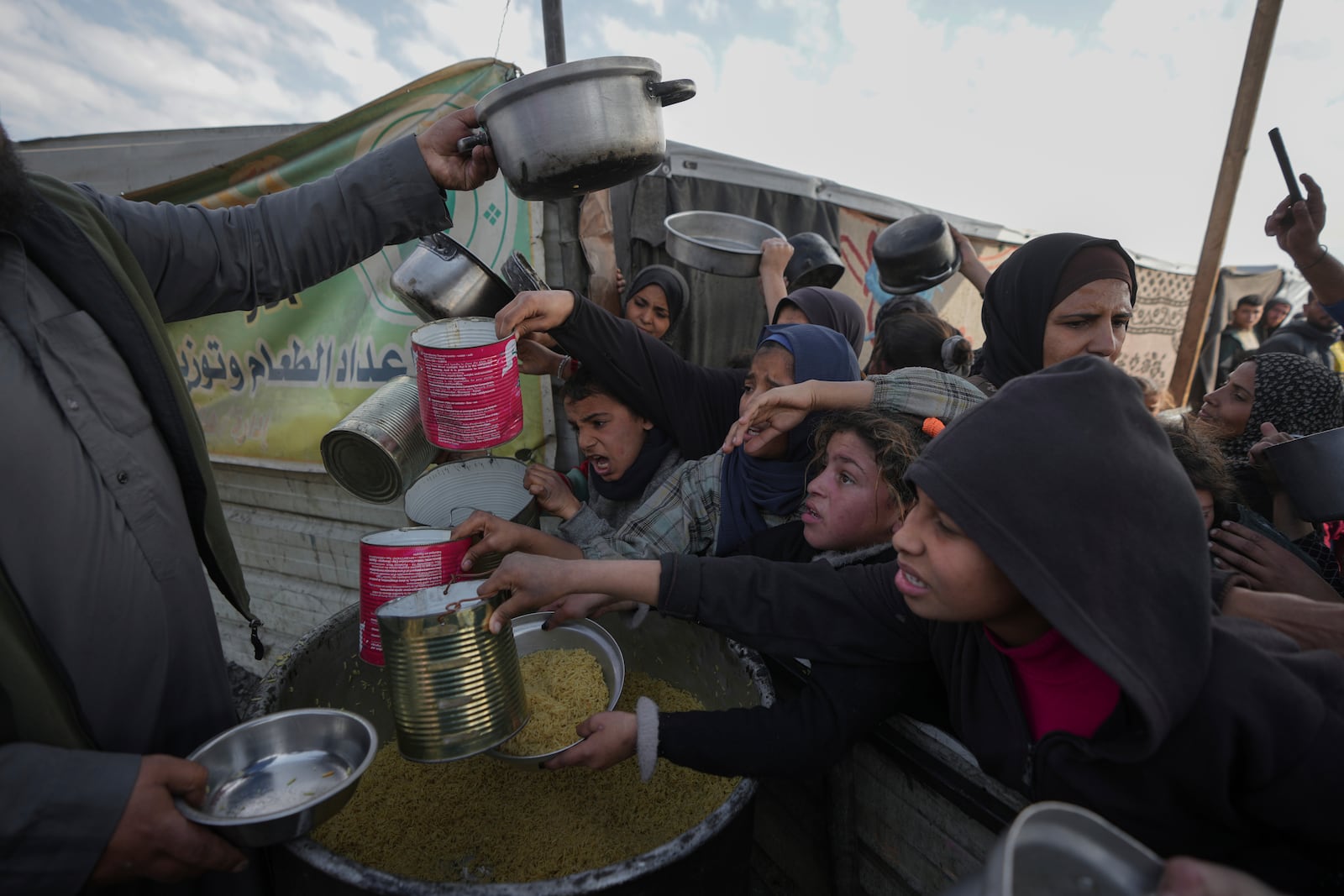 FILE - Palestinians struggle for food at a distribution center in Khan Younis, Gaza Strip, on Jan. 9, 2025. (AP Photo/Abdel Kareem Hana, File)