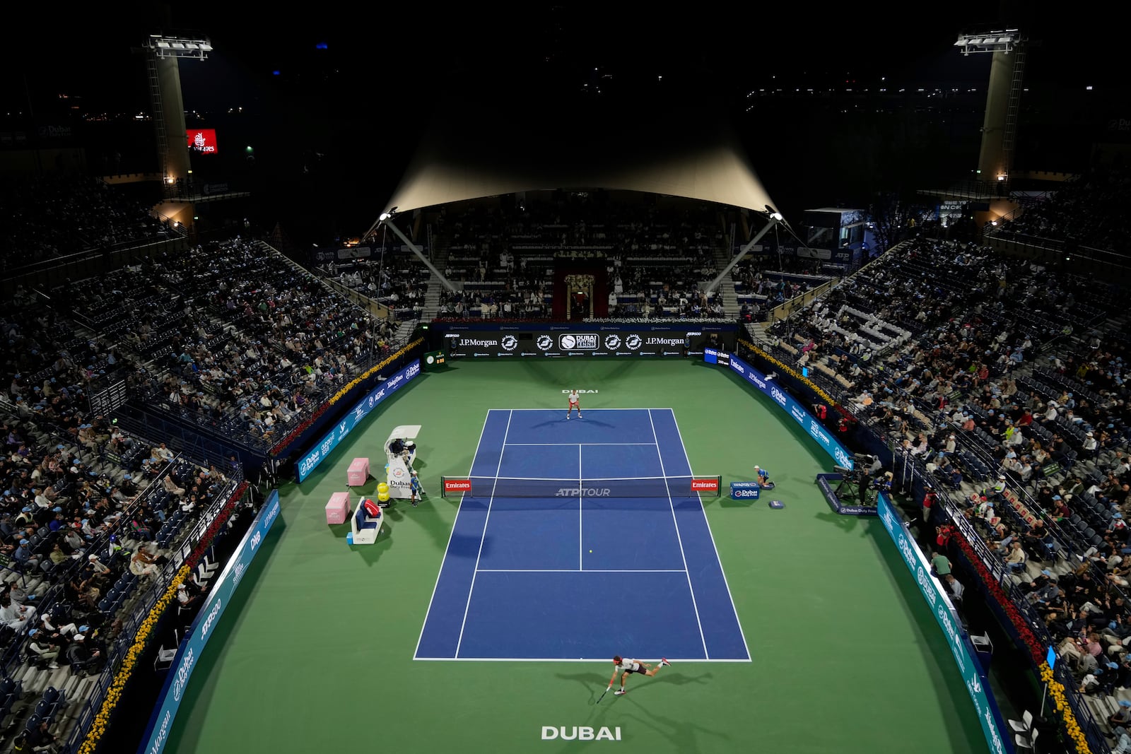 Stefanos Tsitsipas of Greece, in the foreground, returns the ball to Felix Auger-Aliassime of Canada during the men's singles final match of Dubai Duty Free Tennis Championship in Dubai, United Arab Emirates, on Saturday, March 1, 2025. (AP Photo/Altaf Qadri)