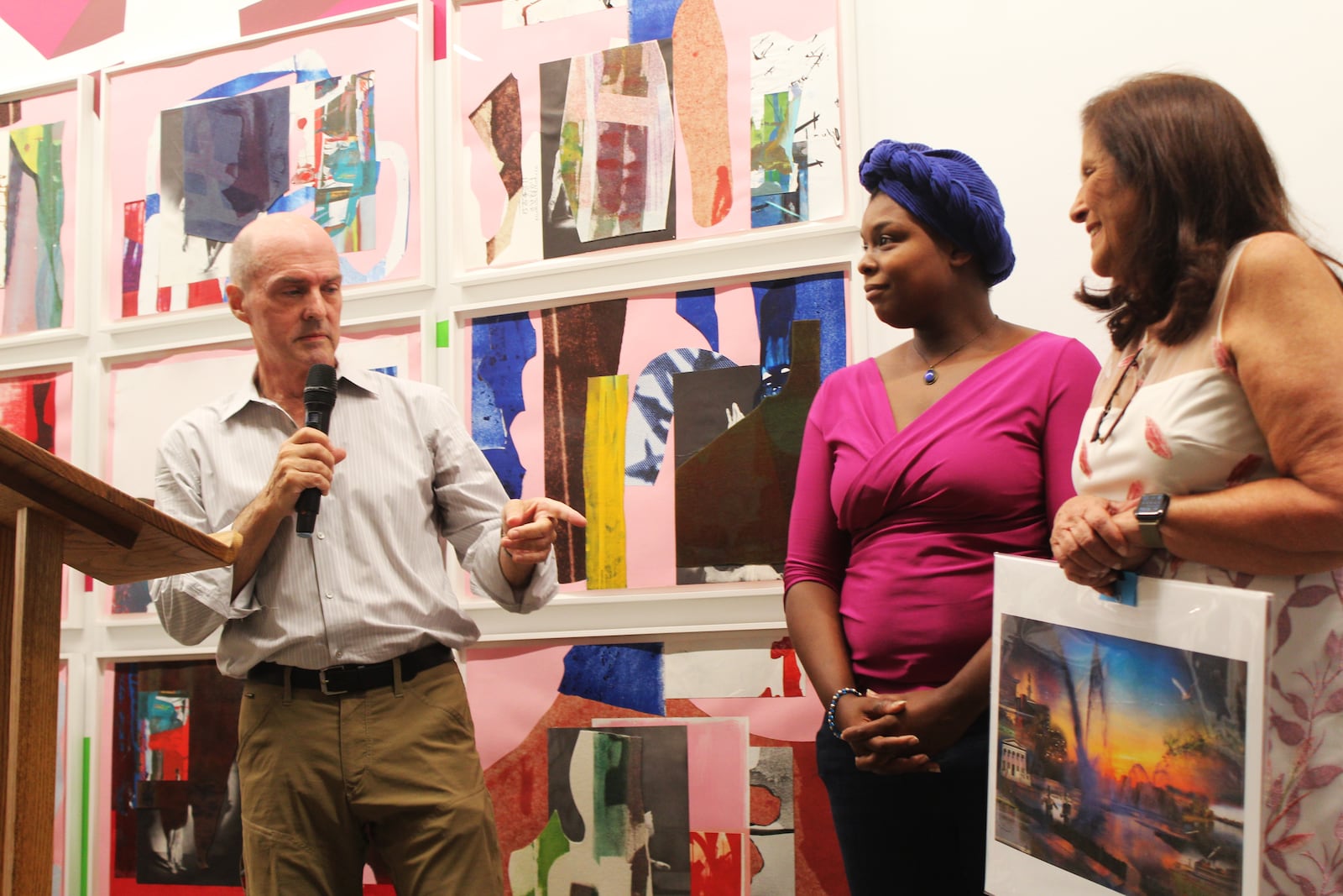 Local photographer and artist Andy Snow presented Sandy Gudorf with an illustration of downtown Dayton during a retirement celebration in June 2023. Cyndie King, curatorial assistant with the Contemporary Dayton, is also pictured. CORNELIUS FROLIK / STAFF