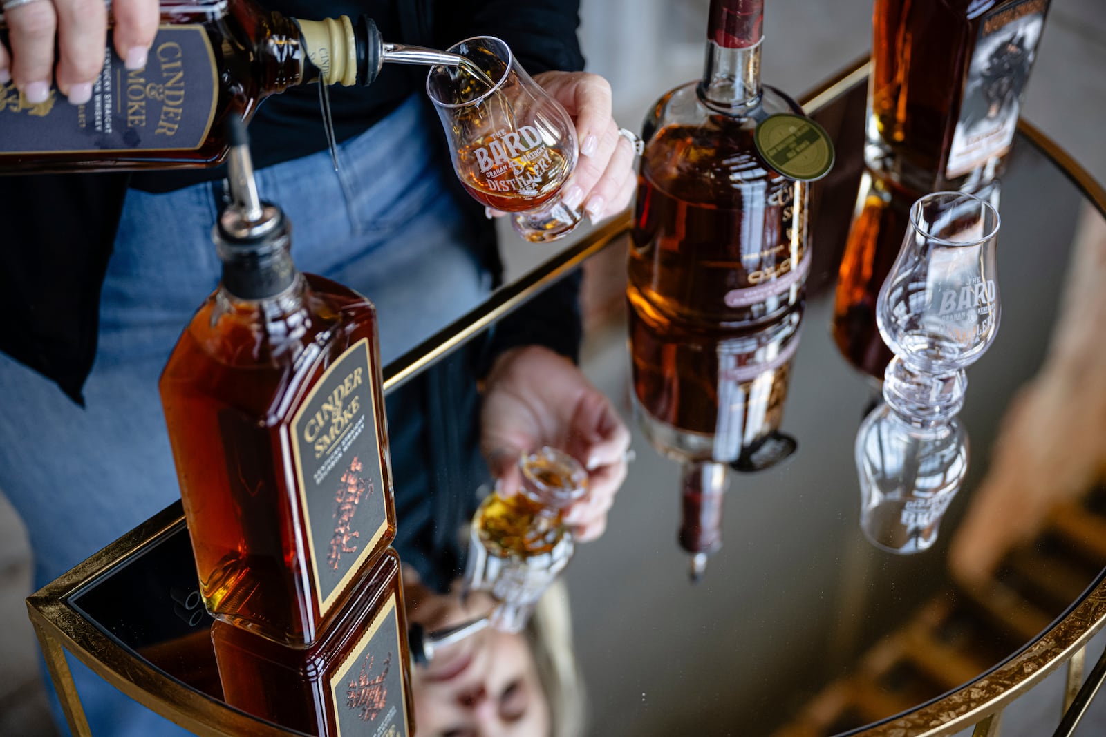 An employee pours a glass of The Bard's product in what will be a new production area at The Bard Distillery in Graham, Ky., Sunday, March 9, 2025. (AP Photo/Jon Cherry)