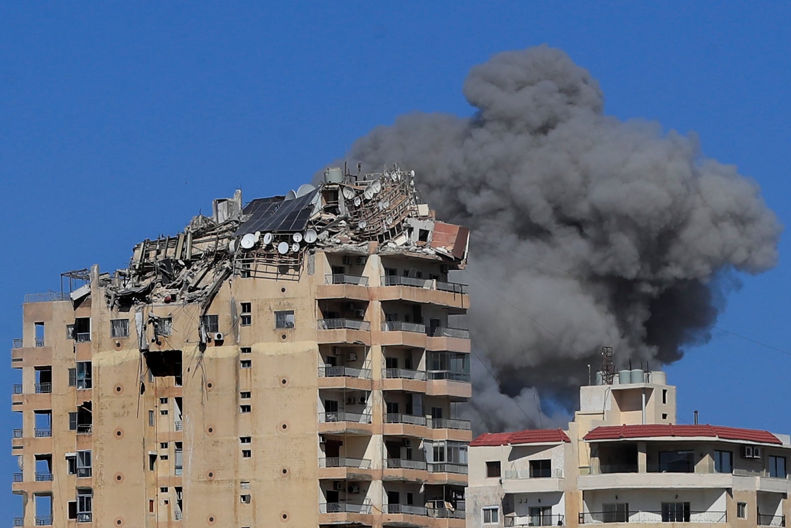 Smoke rises from a building hit in an Israeli airstrike in Tyre, Lebanon, Wednesday, Oct. 23, 2024. (AP Photo/Mohammad Zaatari)