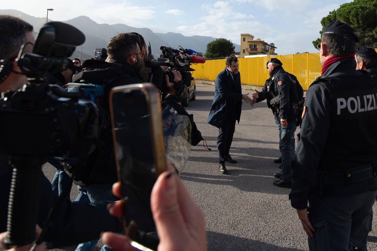 Italy's deputy premier, Matteo Salvini, shakes hands with a police upon his arrival at the Palermo's court Friday Dec. 20, 2024 as he awaits a verdict for preventing some 100 migrants from disembarking a rescue boat in 2019 when he was interior minister. (AP Photo/Salvatore Cavalli)