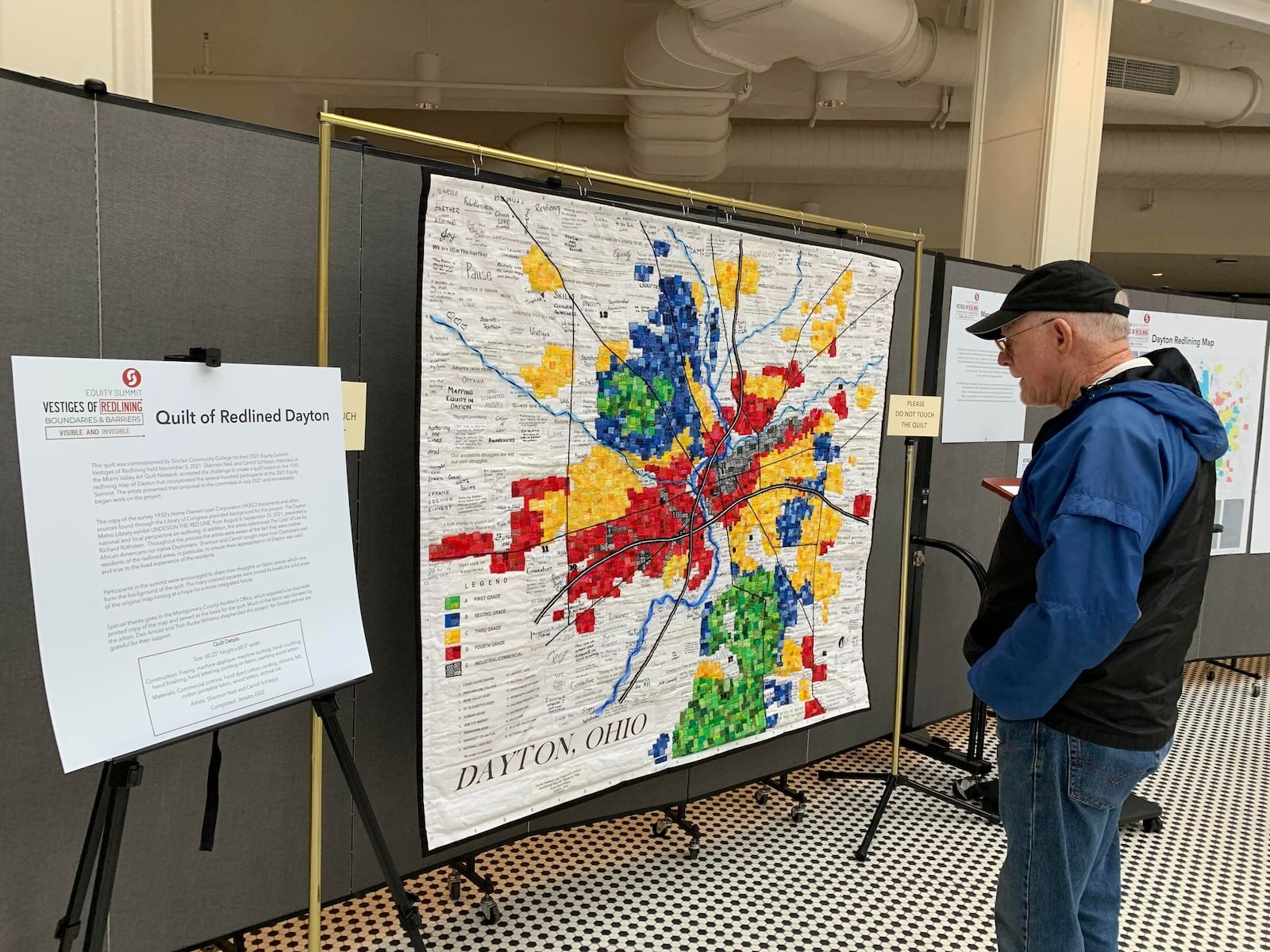 Several exhibits on display during the Imagining Community Symposium in the rotunda of the Arcade examine and map the disparities between majority-white and non-white communities. This quilt depicts the redlining map drawn by the U.S. government and used by banks for decades to systematically deny minority communities home loans.