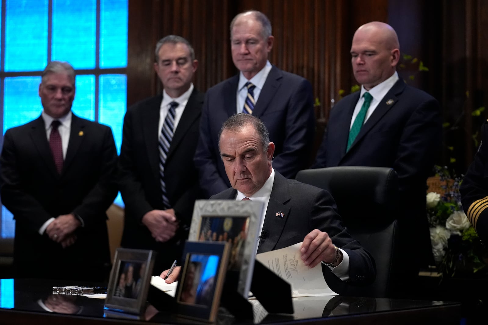 Gov. Mike Kehoe sits at his desk to sign executive orders shortly after being sworn in as Missouri's 58th governor Monday, Jan. 13, 2025, in Jefferson City, Mo. (AP Photo/Jeff Roberson)