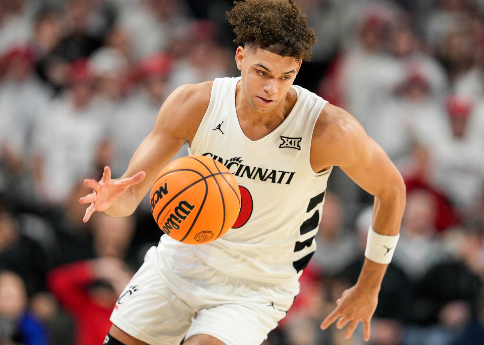 Cincinnati guard Dan Skillings Jr. dribbles after a steal during the first half of an NCAA college basketball game against Kansas, Saturday, Jan. 11, 2025, in Cincinnati. (AP Photo/Jeff Dean)