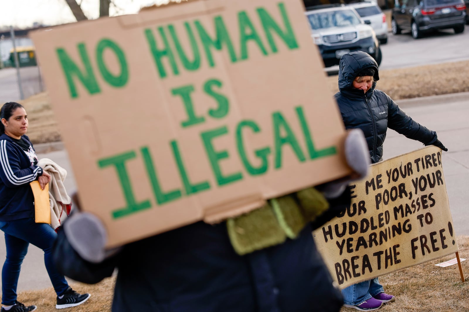 FILE - Supporters hold signs during a protective accompaniment vigil for people arriving at their immigration appointments outside of the U.S. Immigration and Customs Enforcement office in Cedar Rapids, Iowa, Feb. 4, 2025. (Jim Slosiarek/The Gazette Via AP)