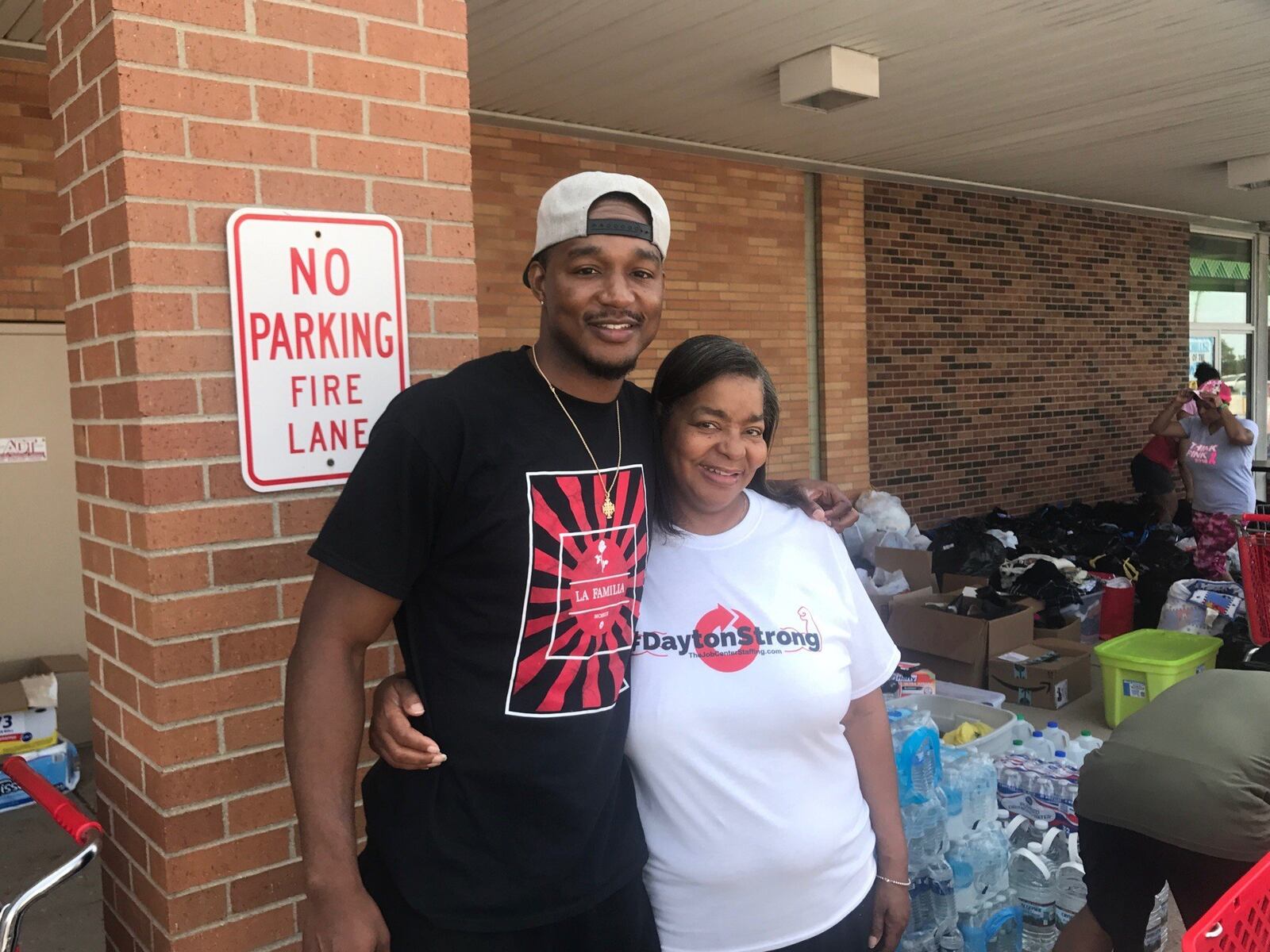 Former Trotwood-Madison and Univeristy of Dayton standout Chris Wright, pictured Saturday morning with his mom Ernestine Grigsby, the head of food services at Trotwood Middle School. Wright and his Wright Way Foundation have set up a goods collection site and a help area in the Big Lots parking lot on Salem Avenue in Trotwood. Tom Archdeacon/STAFF