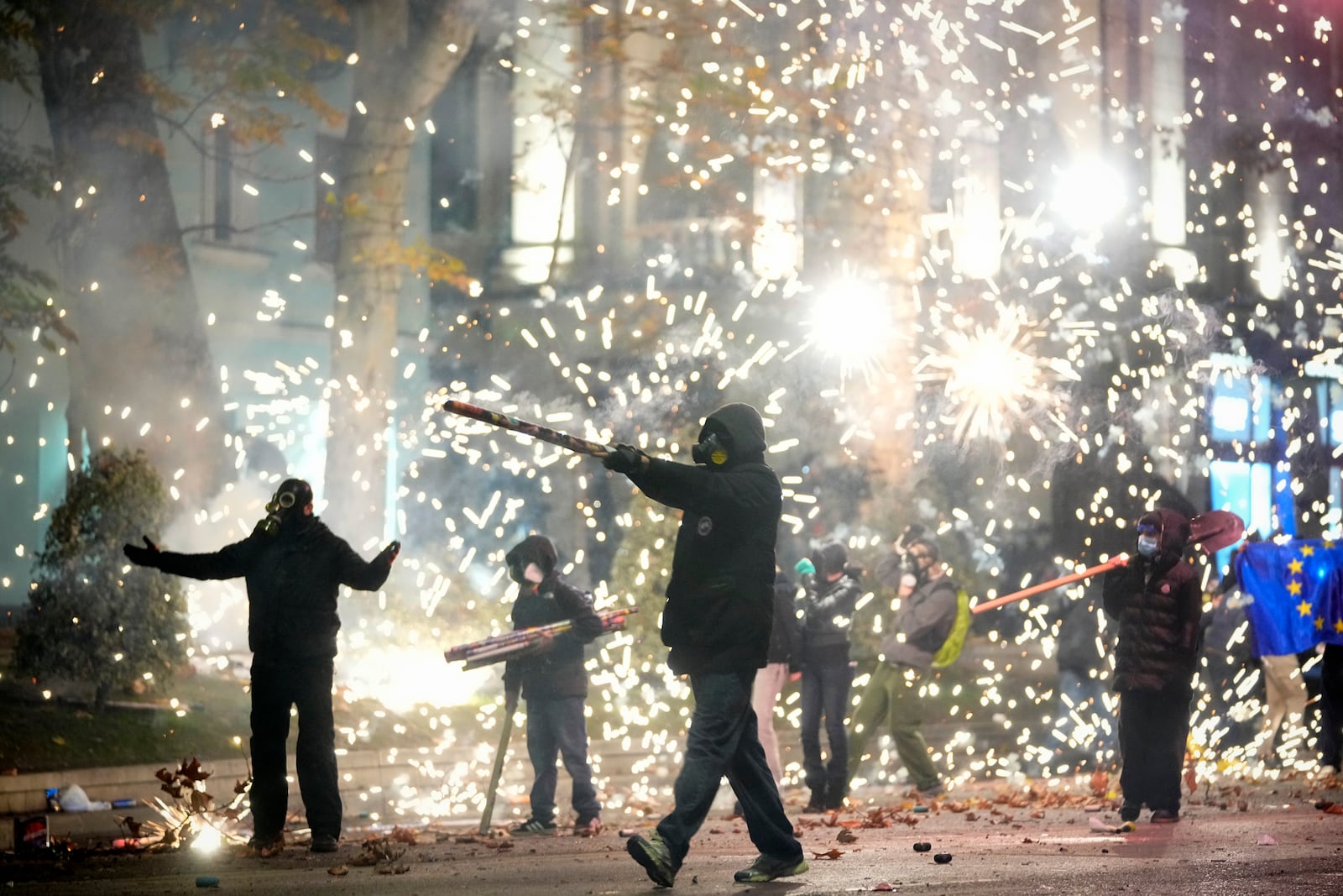 Demonstrators launch firecrackers during a protest against the government's decision to suspend negotiations on joining the European Union in Tbilisi, Georgia, early Wednesday, Dec. 4, 2024. (AP Photo/Pavel Bednyakov)