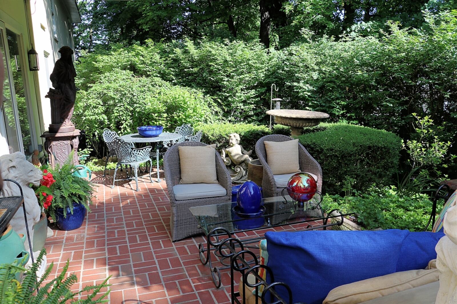 The patio doors open to the paver-brick patio, which is semi-private as it is surrounded by mature trees.