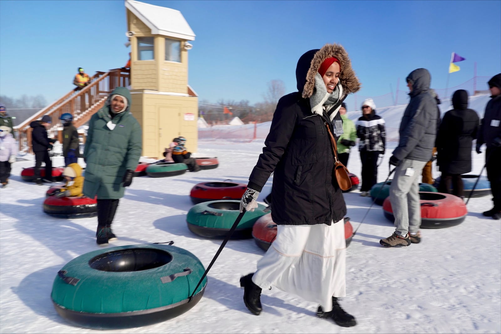 Nasrieen Habib, left, and Makiya Amin pull their snow tubes on top of a hill during an outing organized by the group Habib founded to promote outdoors activities among Muslim women, at Elm Creek Park Reserve in Maple Grove, Minn., on Jan. 4, 2025. (AP Photo/Mark Vancleave)