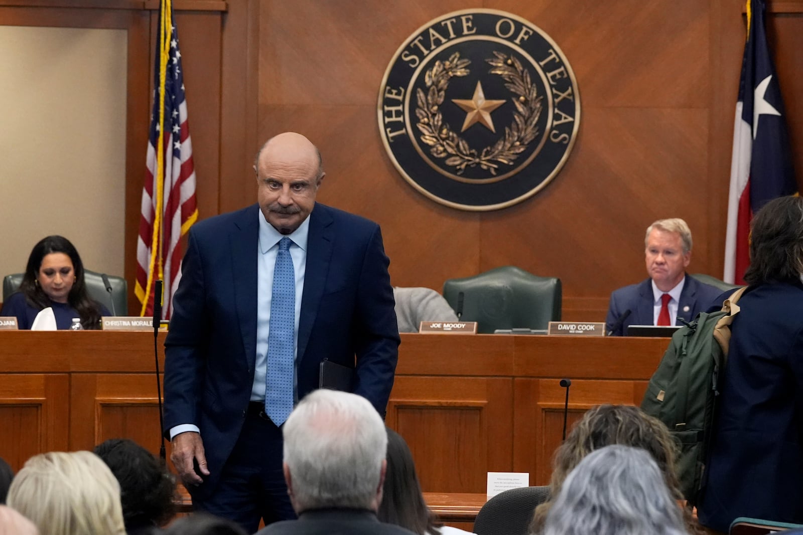 Dr. Phil McGraw, center, leaves the room after giving testimony to a committee discussing the case of death row inmate Robert Roberson, Monday, Oct. 21, 2024, in Austin, Texas. (AP Photo/Tony Gutierrez),