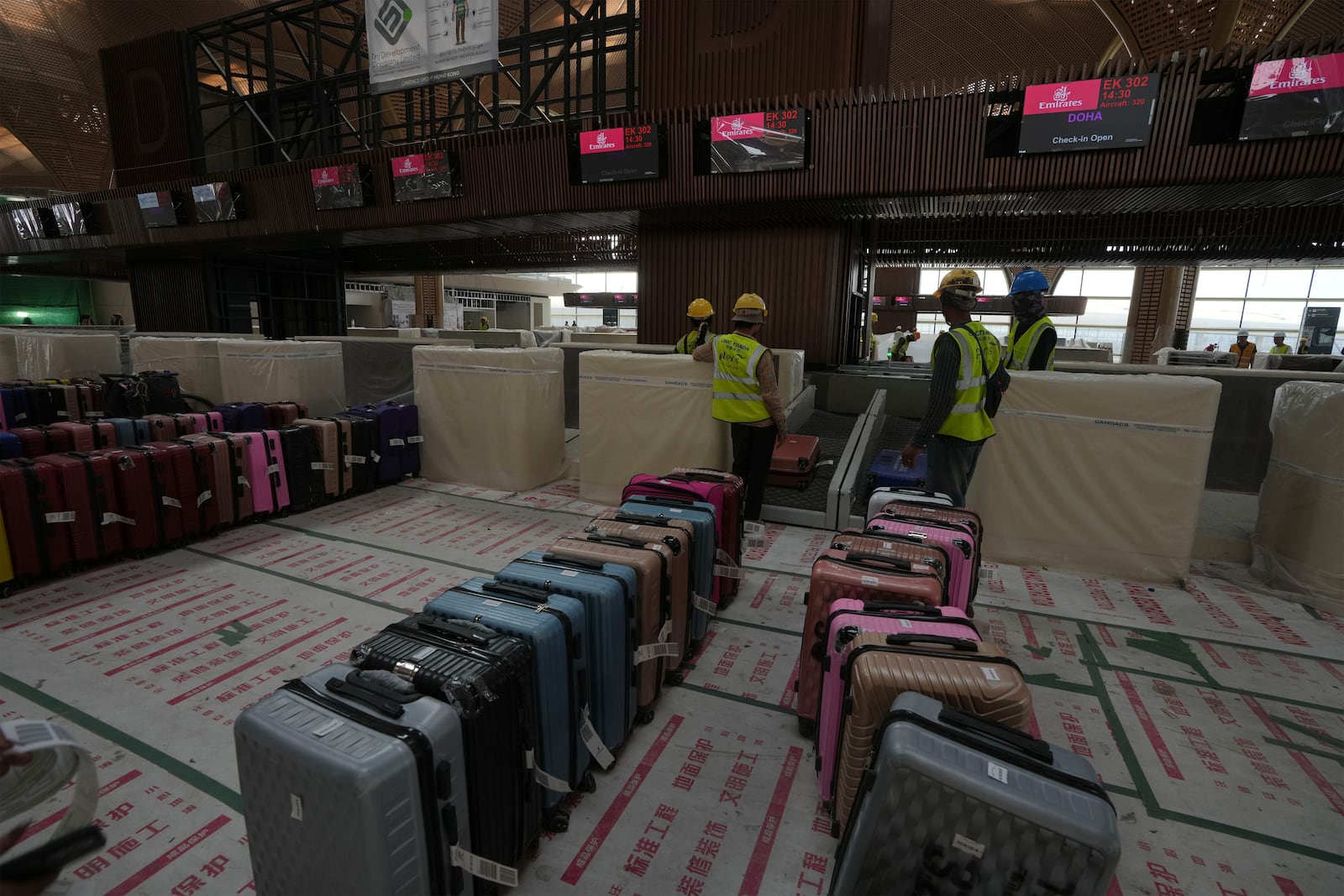 Airport staff members test the luggage machine inside an under construction of a new airport of Techo International Airport at the outskirts of Phnom Penh Cambodia, Friday, March 21, 2025. (AP Photo/Heng Sinith)