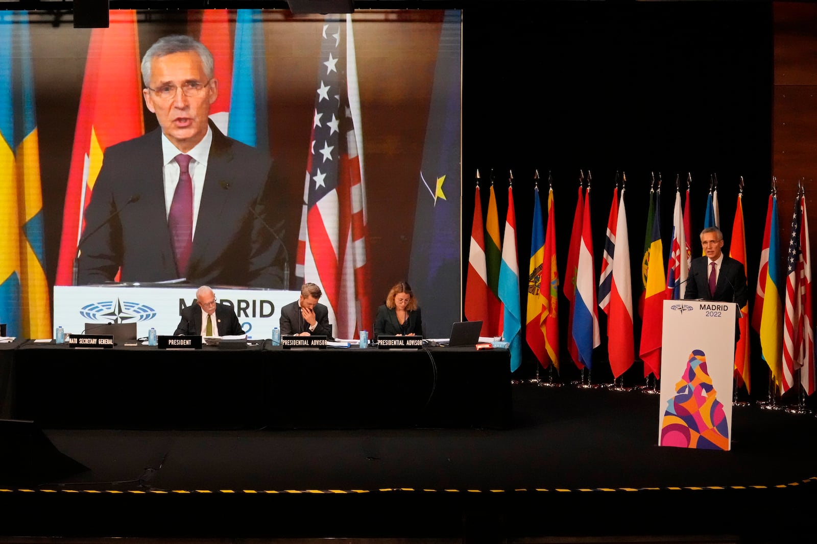 NATO Secretary General Jens Stoltenberg, right, speaks while his image is shown on a large screen during the 68th Annual Session of the NATO Parliamentary Assembly in Madrid, Spain, Monday, Nov. 21, 2022. (AP Photo/Andrea Comas)