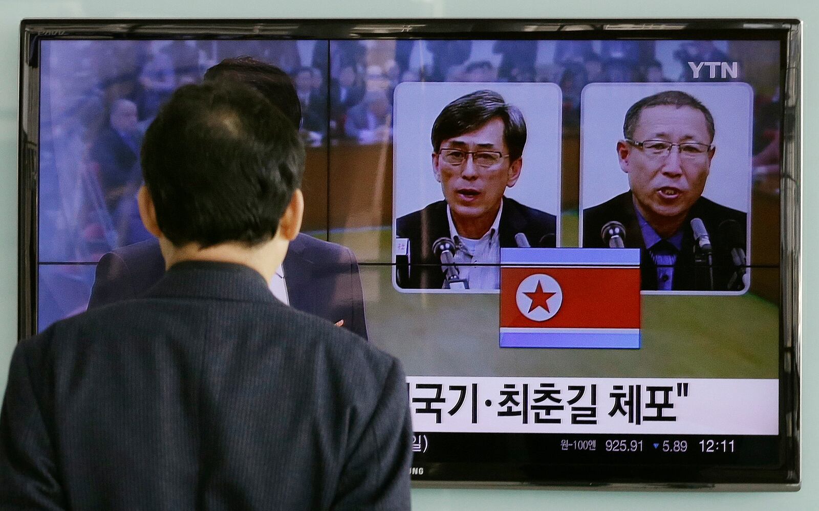 FILE - A South Korean man watches a TV screen reporting about South Korean Kim Kuk Gi, left, and Choe Chun Gil, detained in North Korea, at the Seoul Railway Station in Seoul, South Korea, March 27, 2015. The letters read, "Detained Kim Kuk Gi, Choe Chun Gil." (AP Photo/Ahn Young-joon, File)