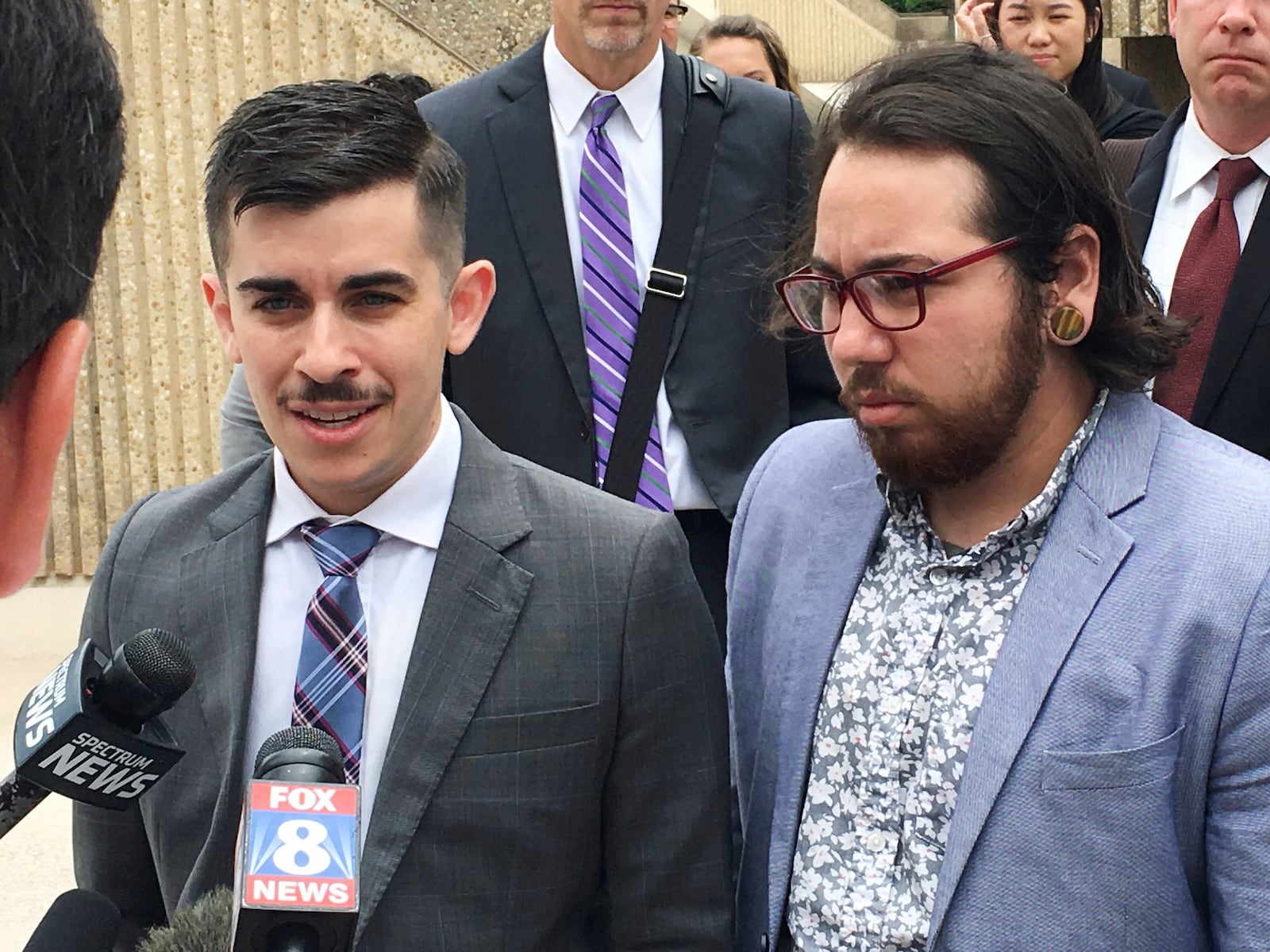 FILE - ACLU lawyer Chase Strangio, left, and plaintiff Joaquin Carcano address reporters after a hearing, June 25, 2018, in Winston-Salem, N.C., on their lawsuit challenging the law that replaced North Carolina's "bathroom bill." Carcano and other transgender plaintiffs argue the new law continues to discourage transgender people from using restrooms that match their gender identity. (AP Photo/Jonathan Drew, File)